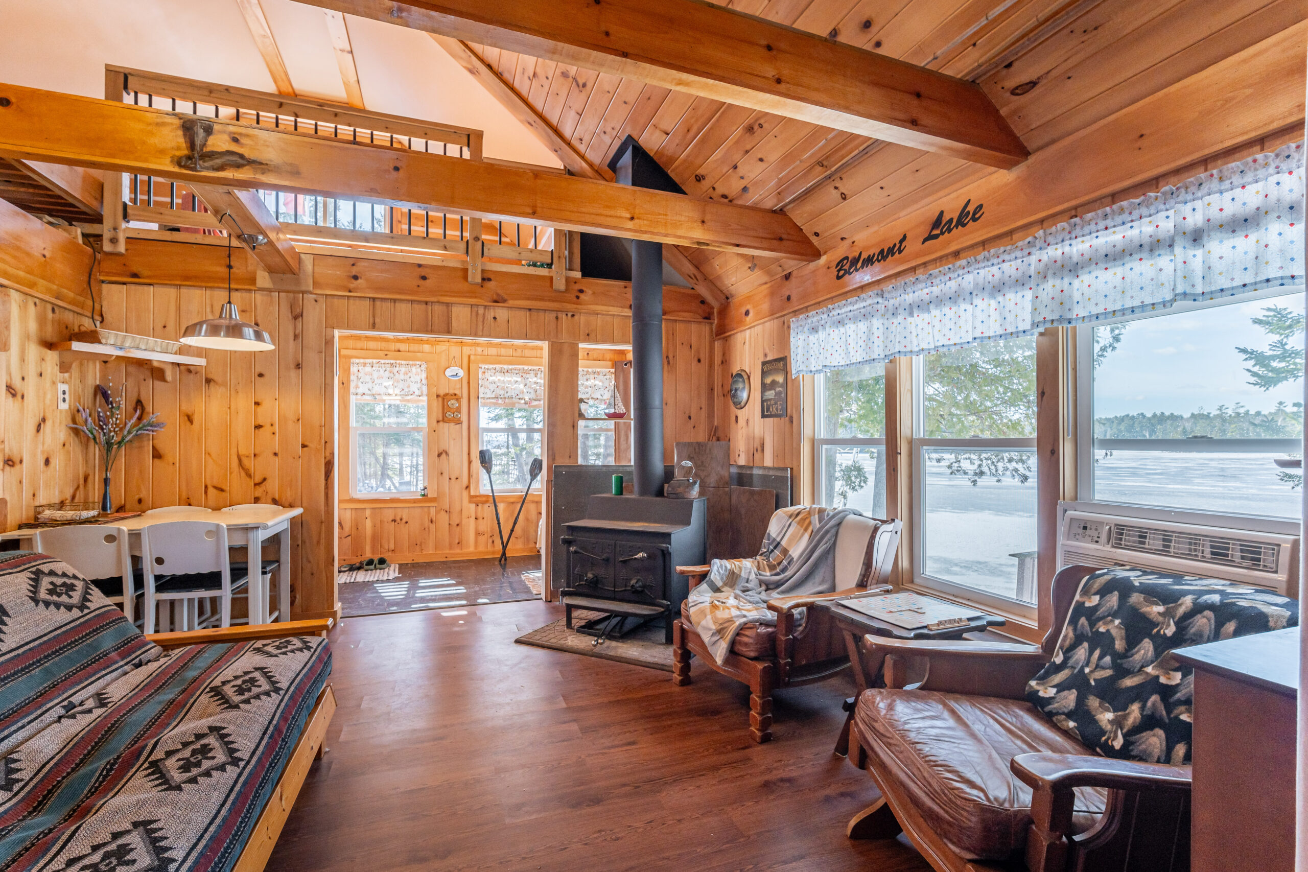 A wood stove in the corner of a spacious wood cabin