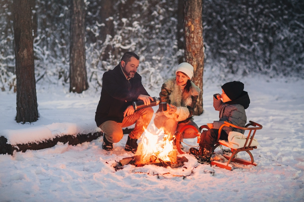 A family huddled around a campfire in the snow