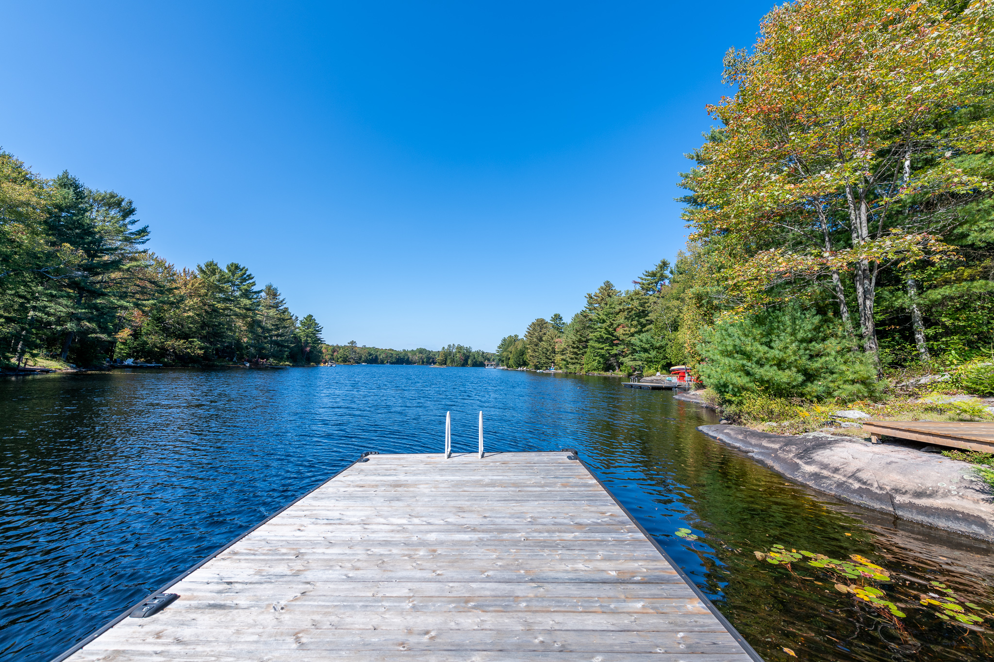 A dock juts out into a blue lake