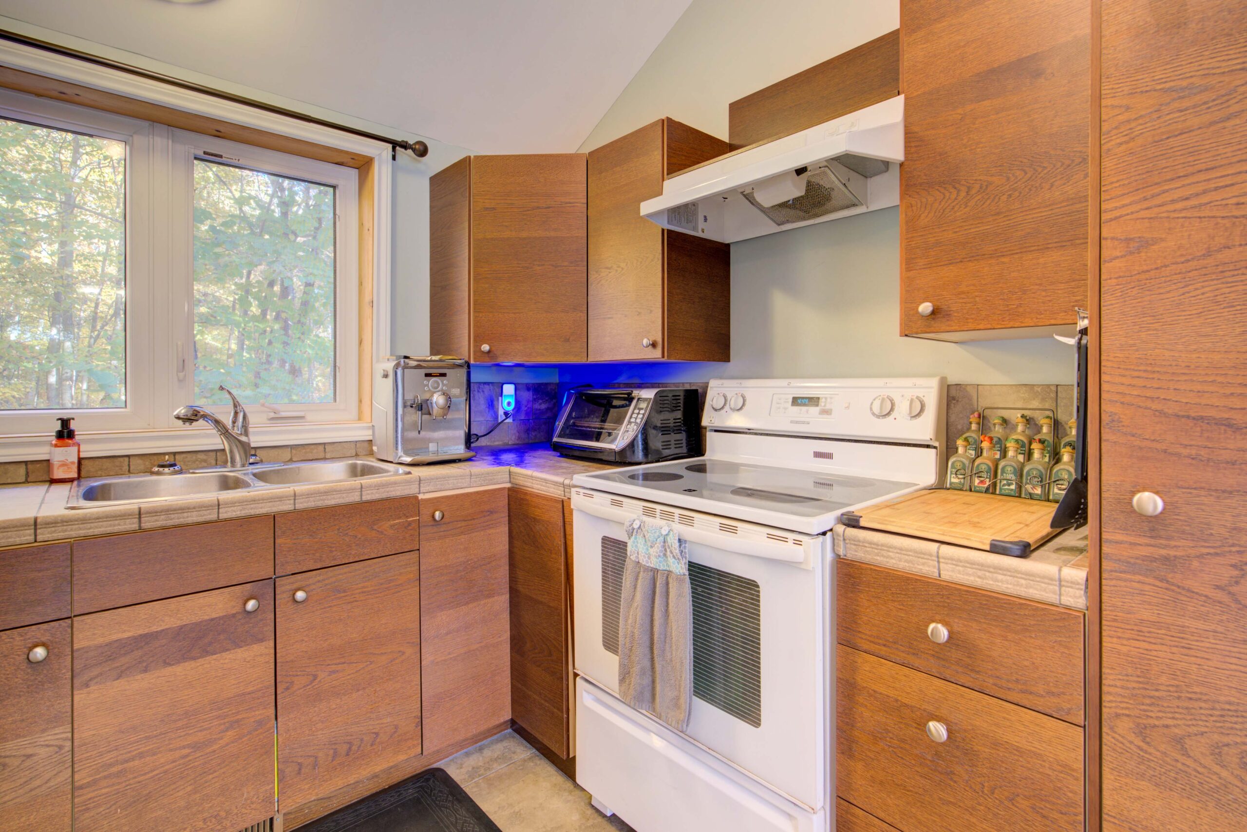 A kitchen with brown wood cabinets and white appliances