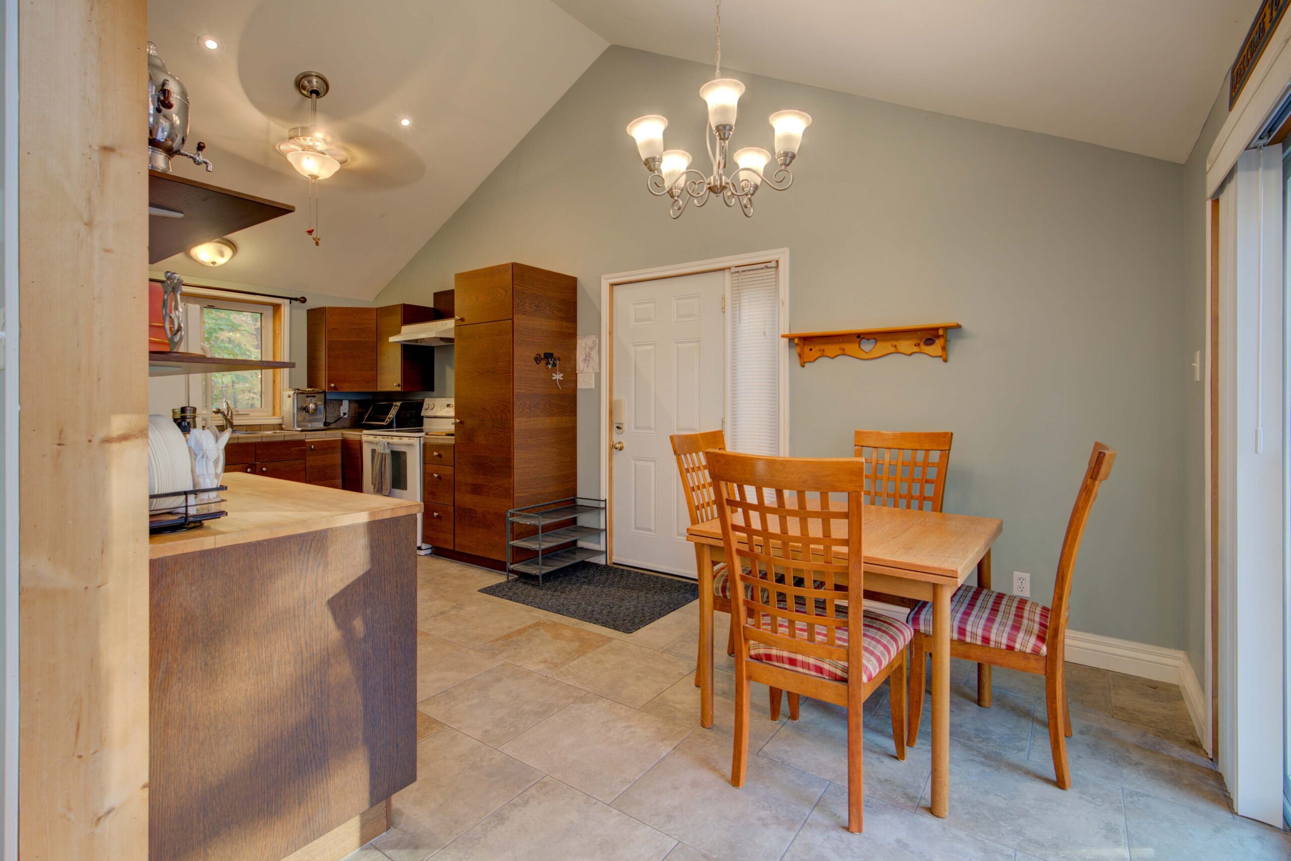 A kitchen with brown cabinets and a small wood dining area