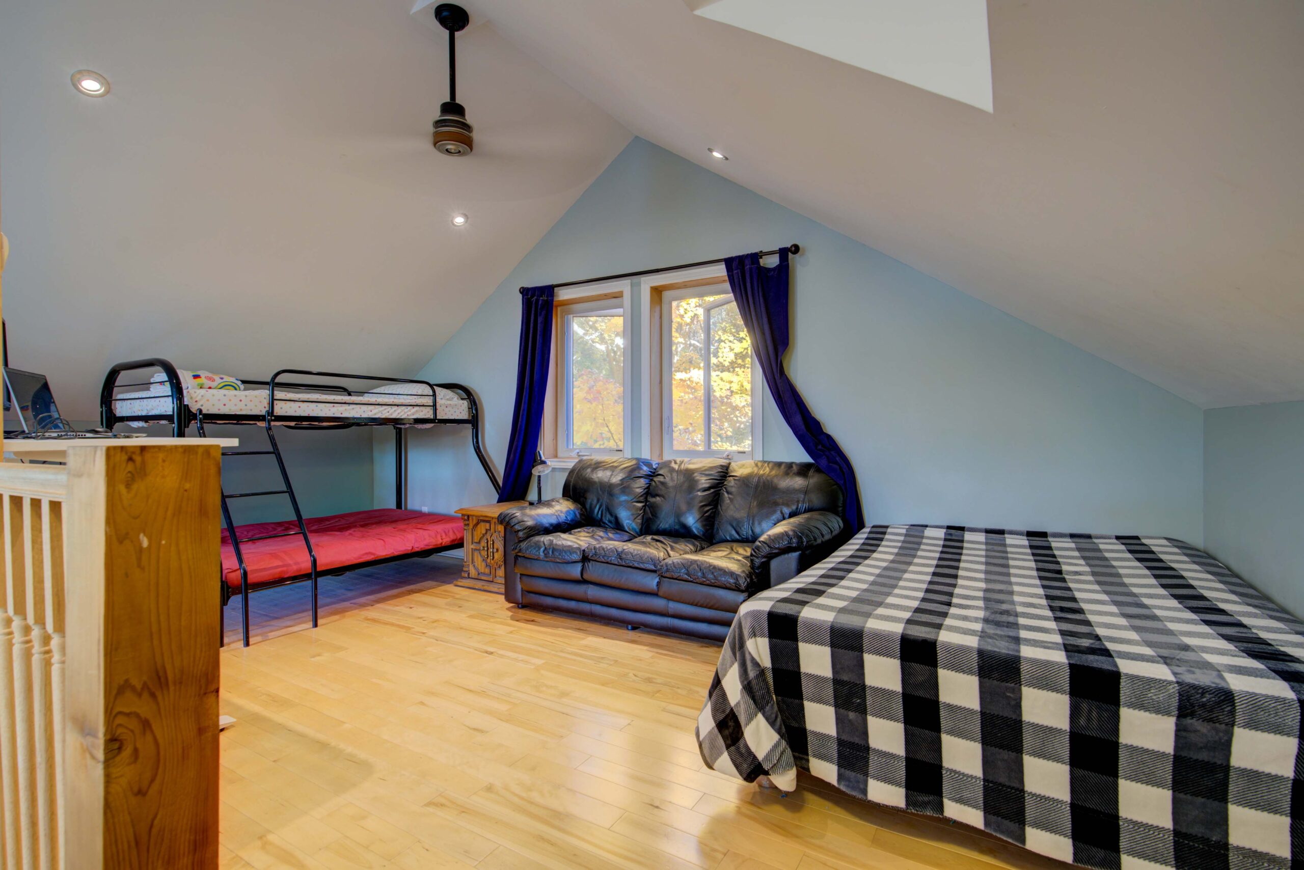 A loft area with blue paint and two beds
