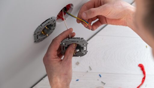 Close-up of hands doing an electrical fix