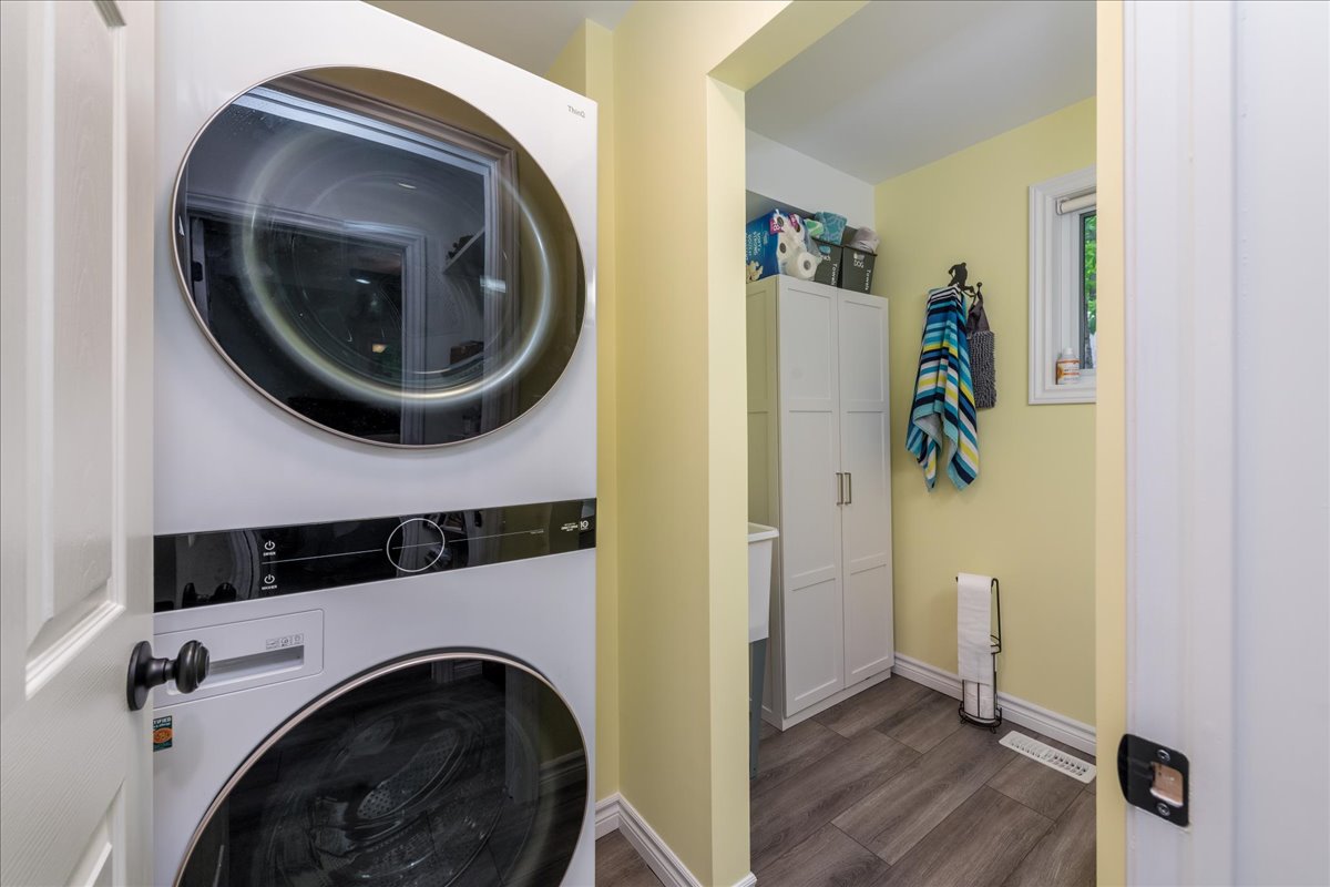 Stacked white laundry machines in a yellow room