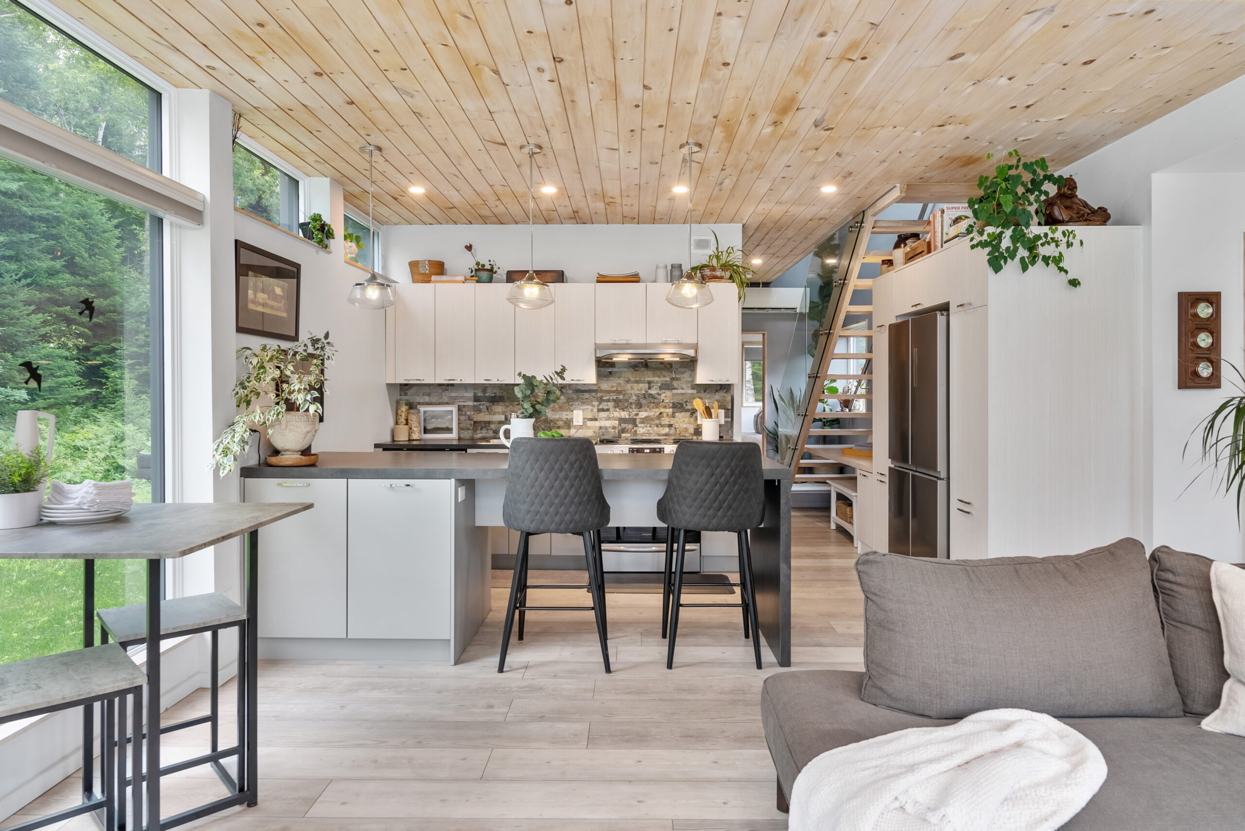 Two grey chairs face a white kitchen island in a white kitchen