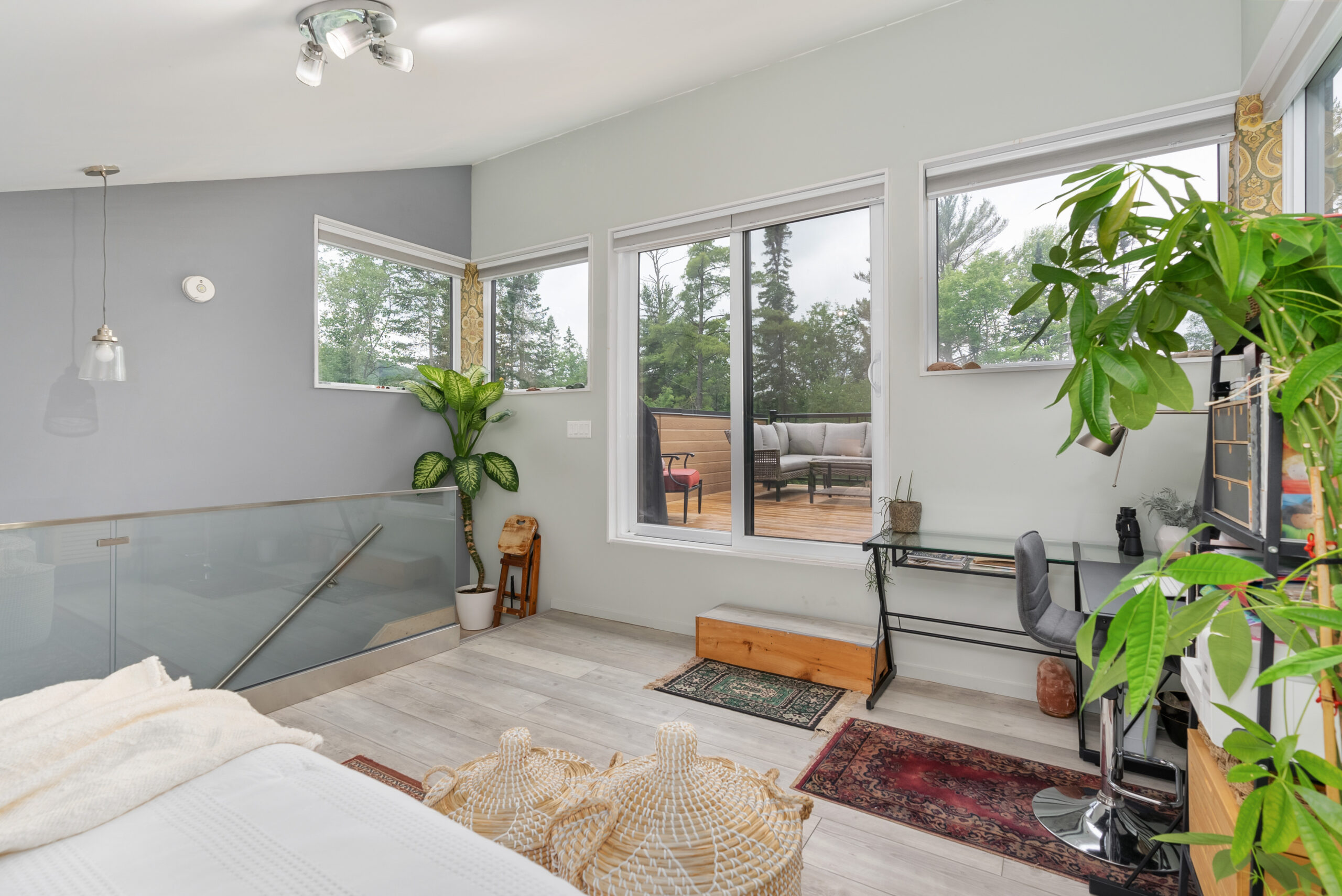 A white bed faces a walkout deck