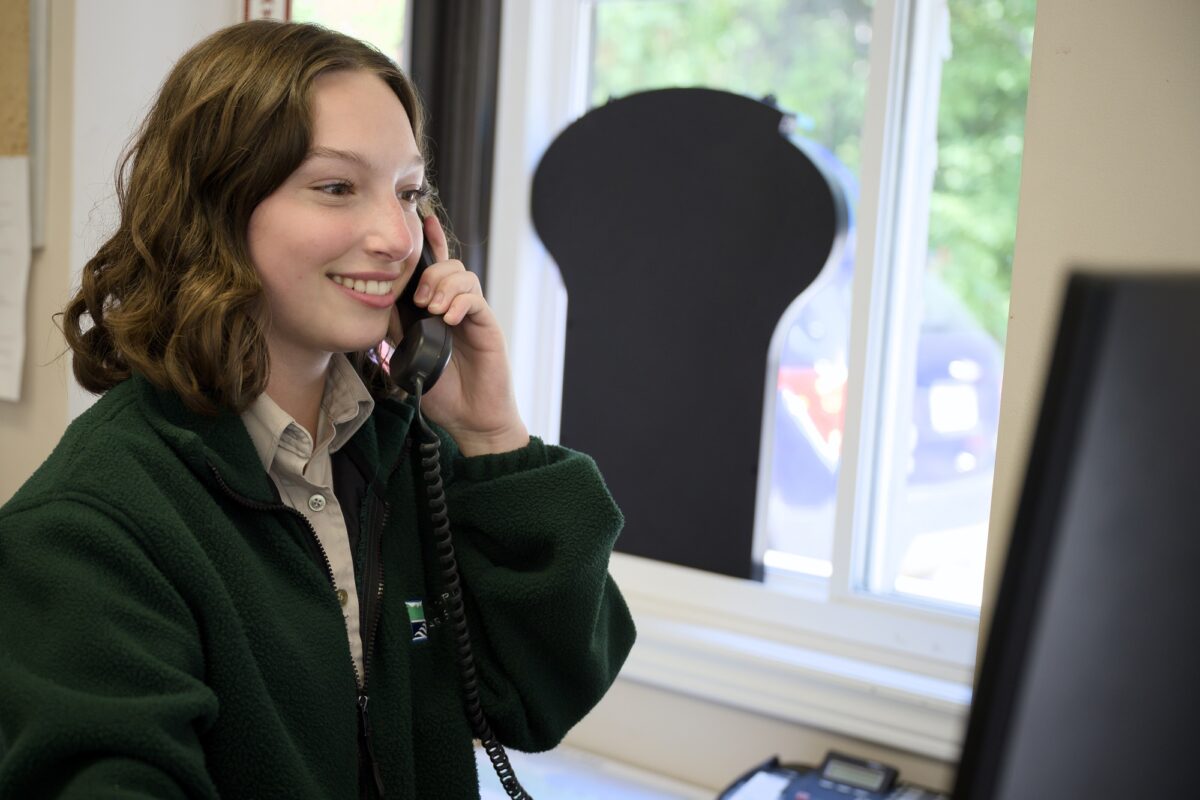 young person in an Ontairo parks sweater answering the phone
