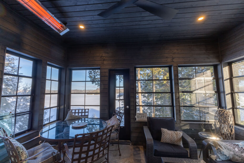 A dark-toned sunroom with patio furniture