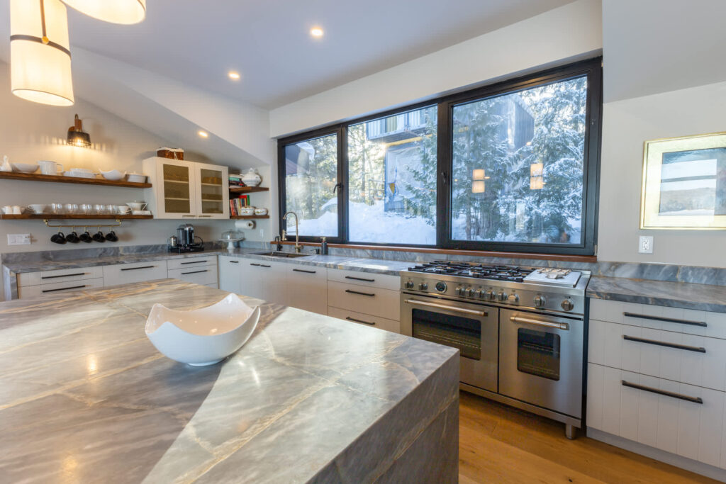 A grey kitchen with a huge grey marbled island