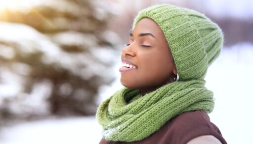 A woman with her eyes closed out in the cold