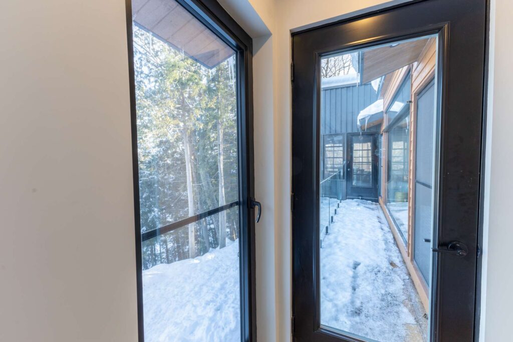 A corner glass door that opens to a thin deck