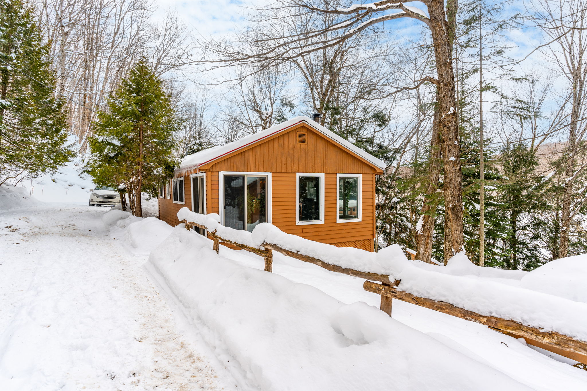 A small wood cottage by a snowy road