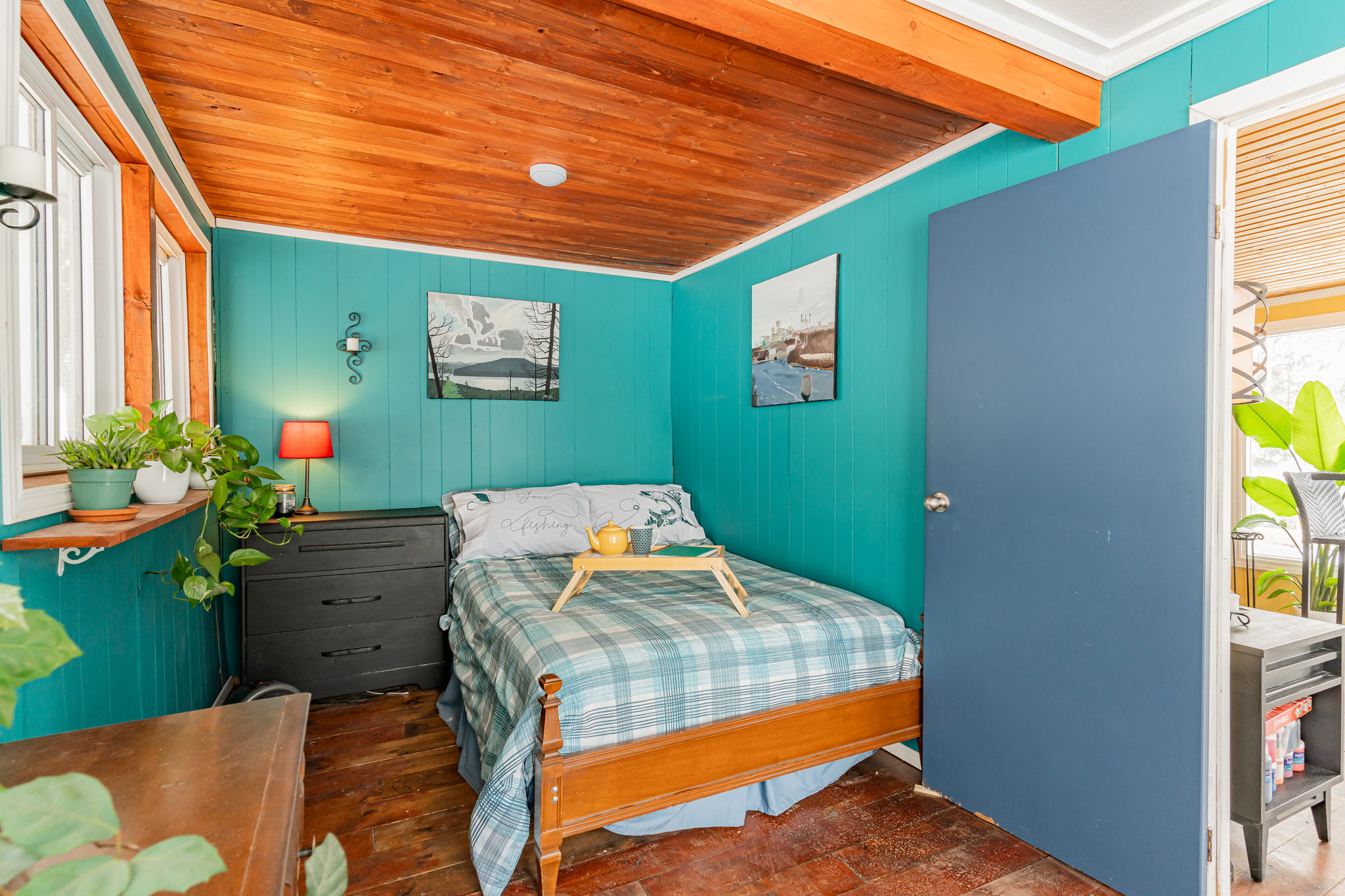 A teal bedroom with a blue plaid bed