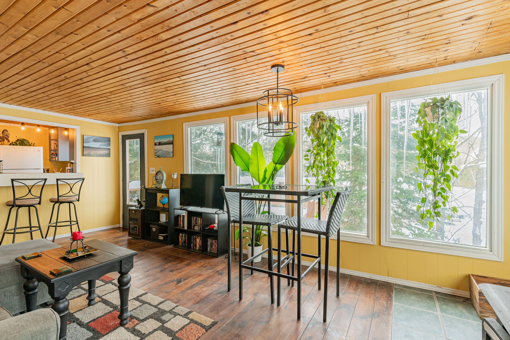 A two-person high-top table is next to a wall of windows