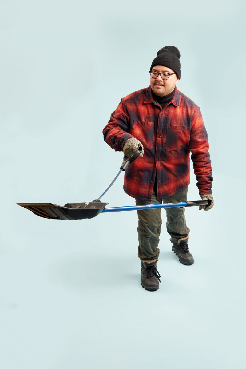 a photo of a person in a plaid jacket holding a shovel