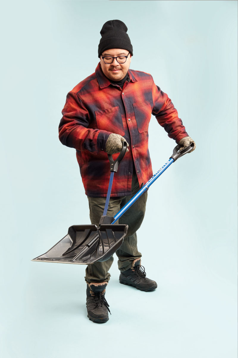 a photo of a person in a plaid jacket holding a shovel