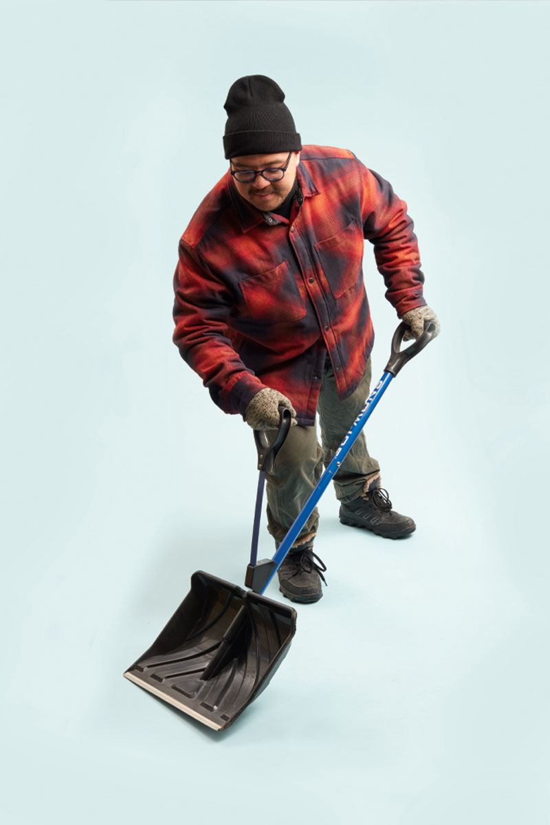 a photo of a person in a plaid jacket holding a shovel