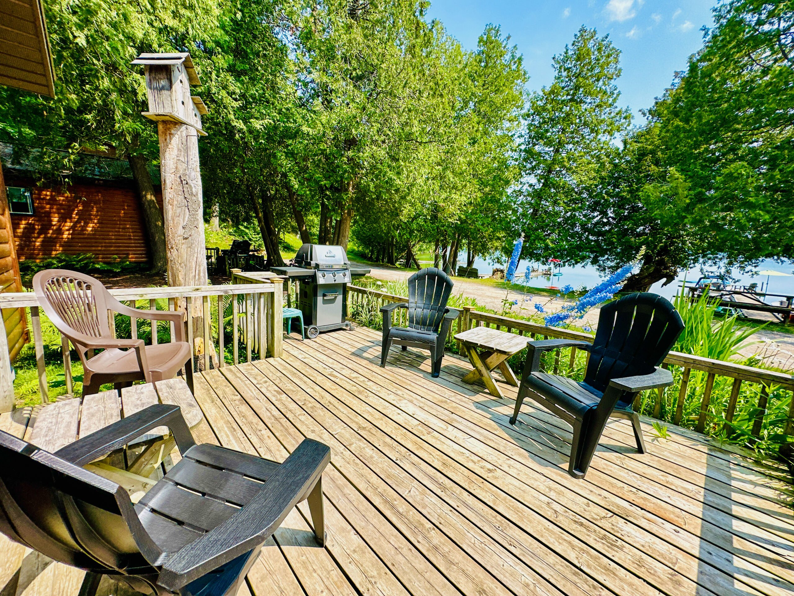 A peaceful outdoor deck attached to a cabin, offering scenic views of the surrounding trees.