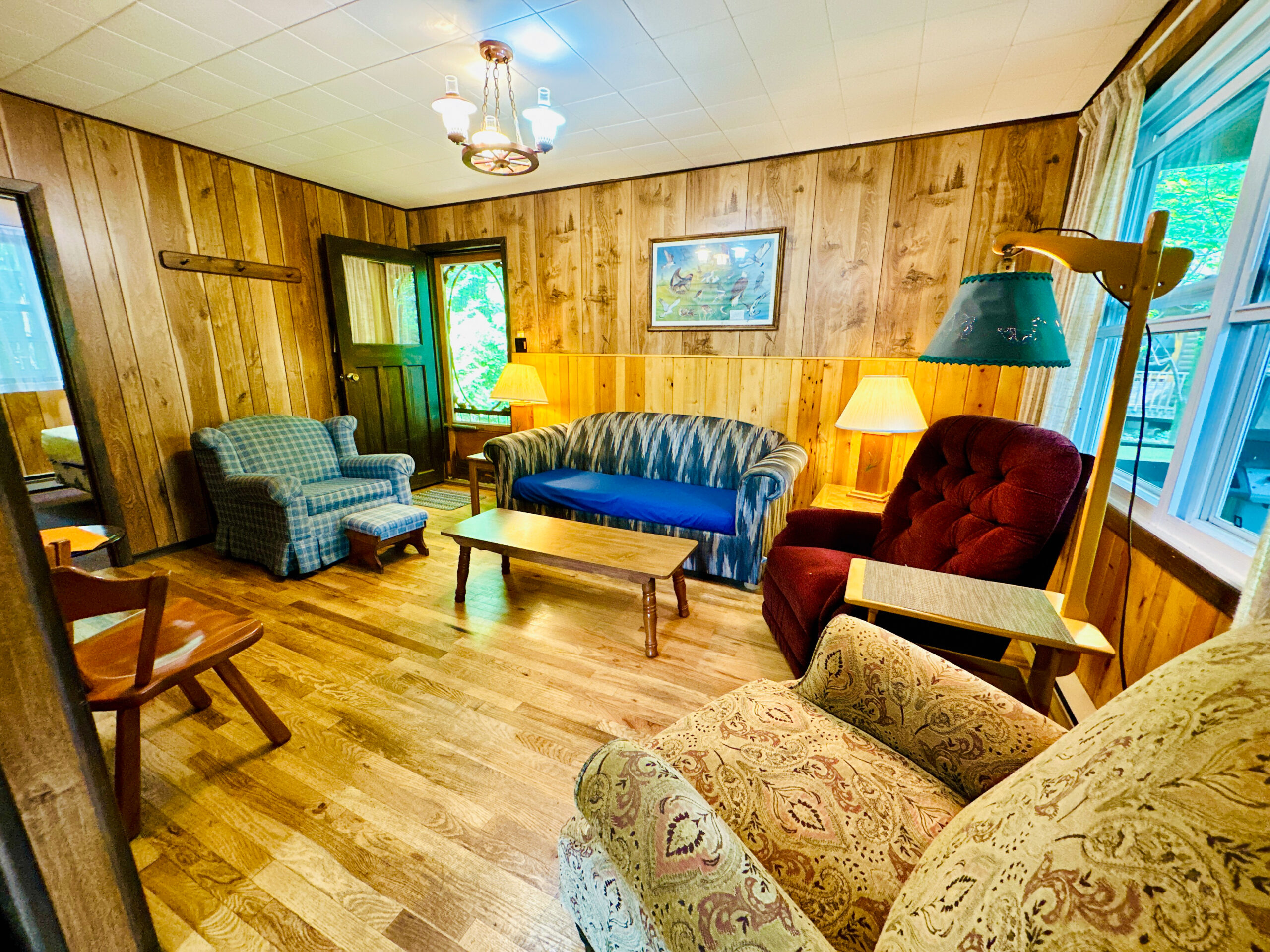 A warm and inviting cabin living room with rustic furniture, large windows, and wood accents.