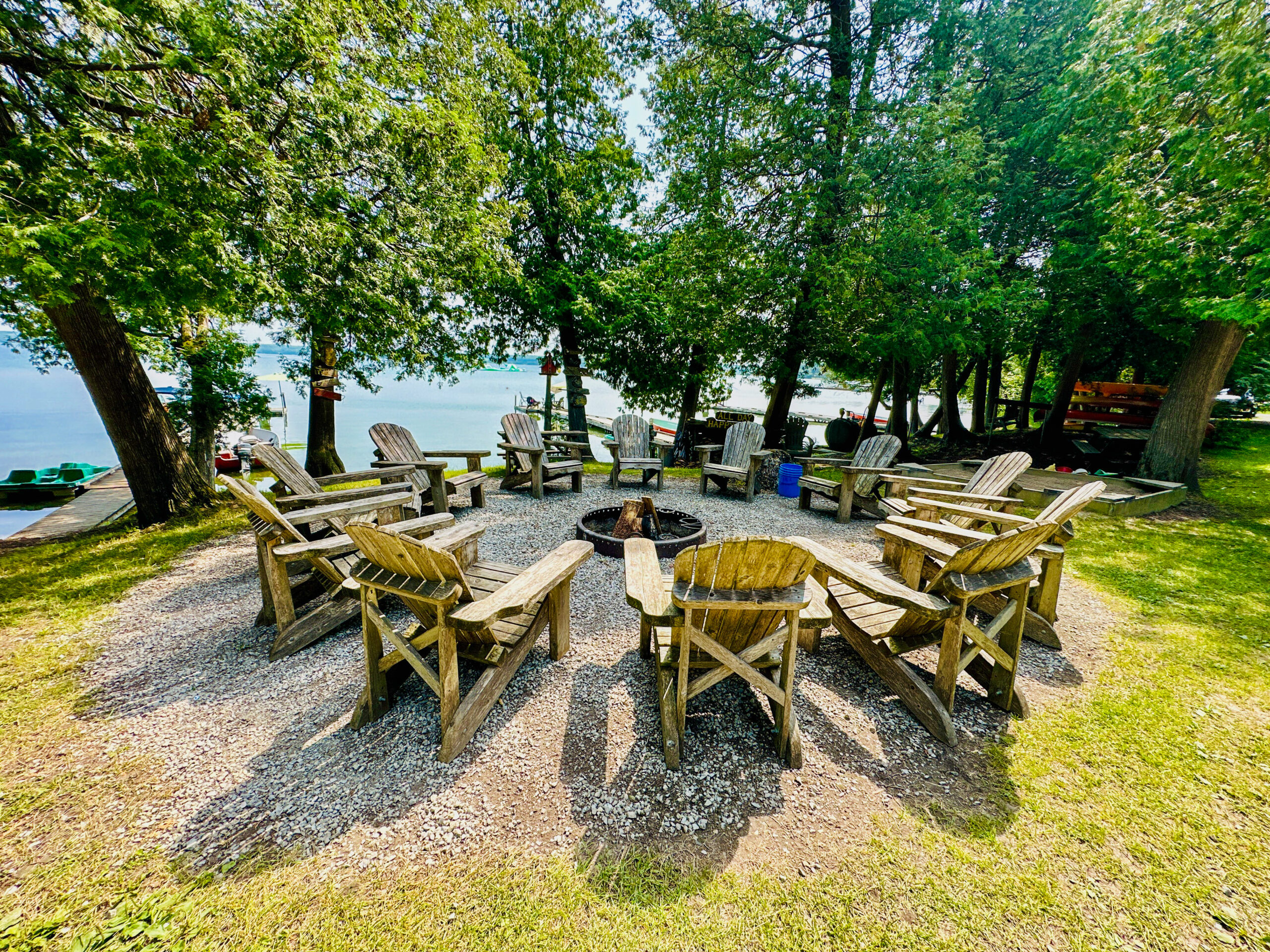 A cozy communal firepit area surrounded by Muskoka chairs, perfect for evening gatherings.