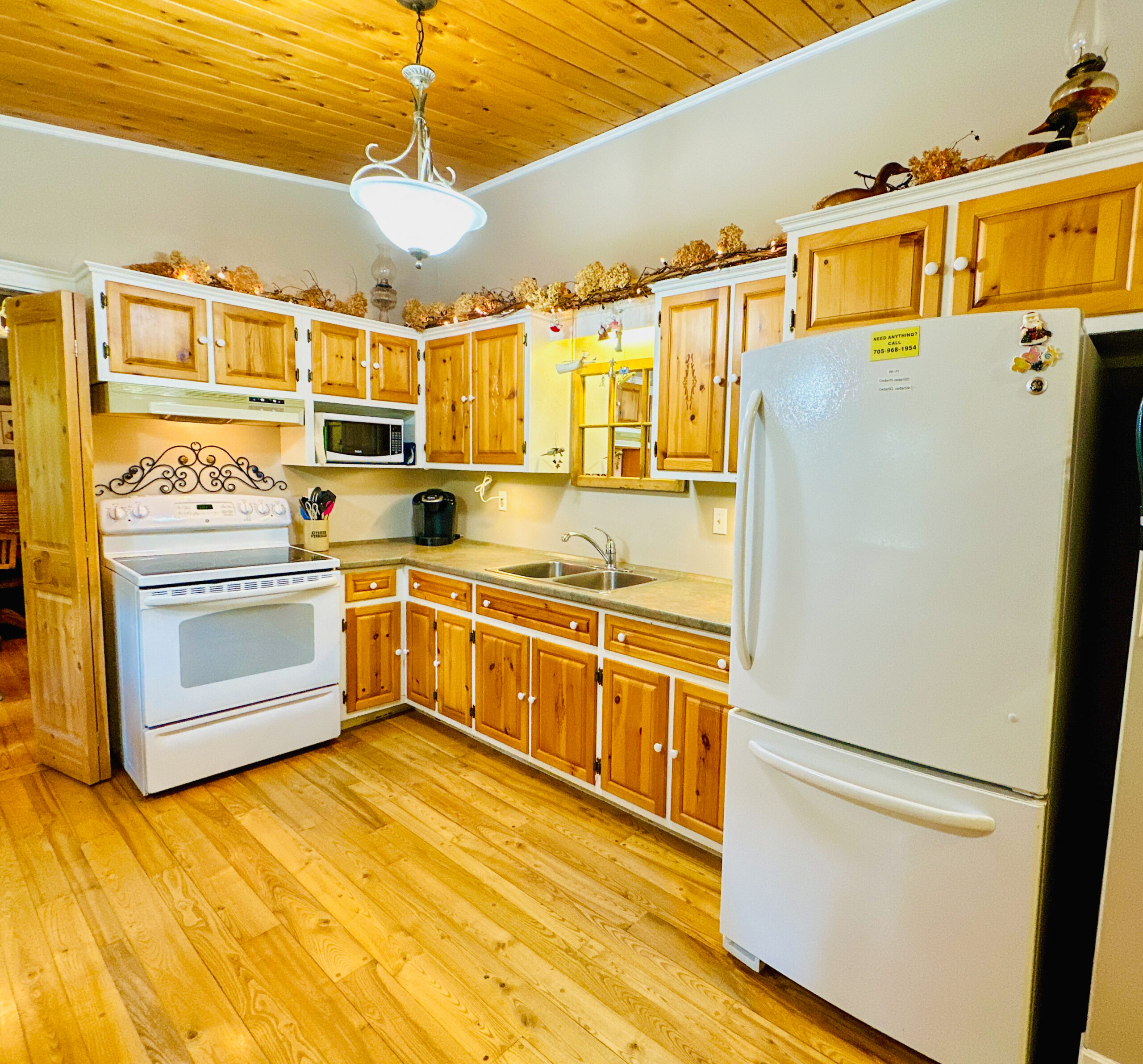 A spacious and fully equipped kitchen in the main house, with wooden cabinetry and modern appliances.