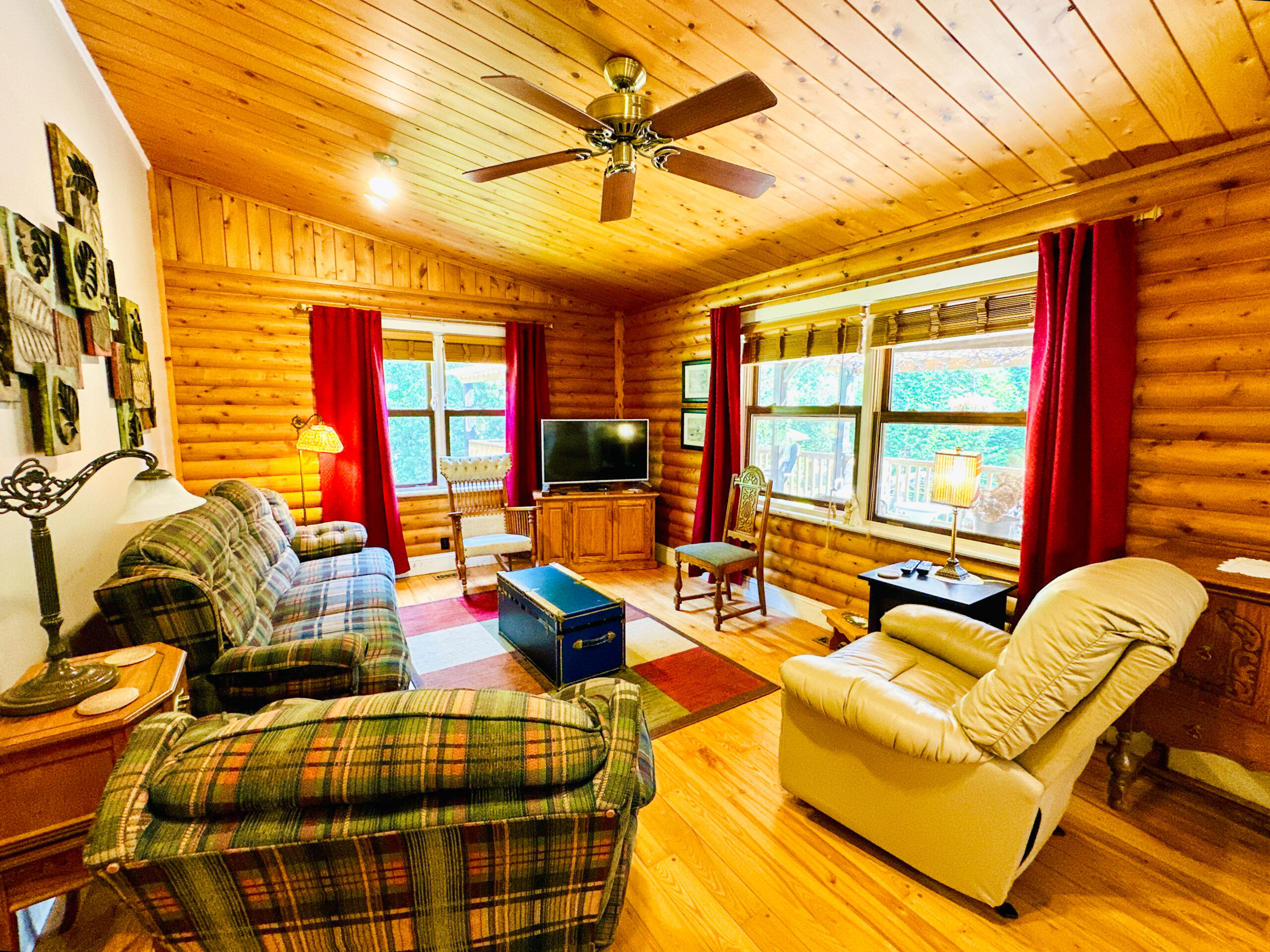 A bright and cozy living area in the main house, featuring a fireplace, comfortable seating, and large windows.