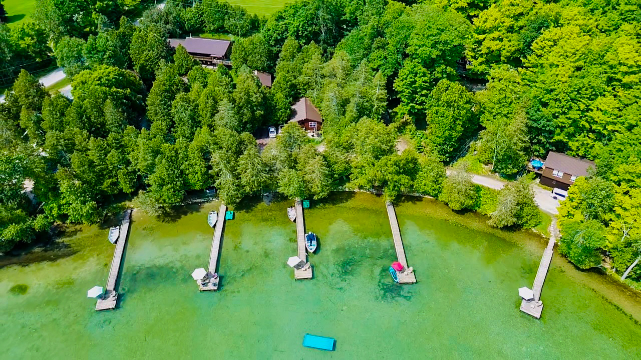 A breathtaking aerial view of Cedar Grove Cottages, nestled among tall trees and expansive waterfront.