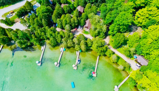 A stunning aerial perspective showing the resort’s sandy shoreline and multiple cabin locations.
