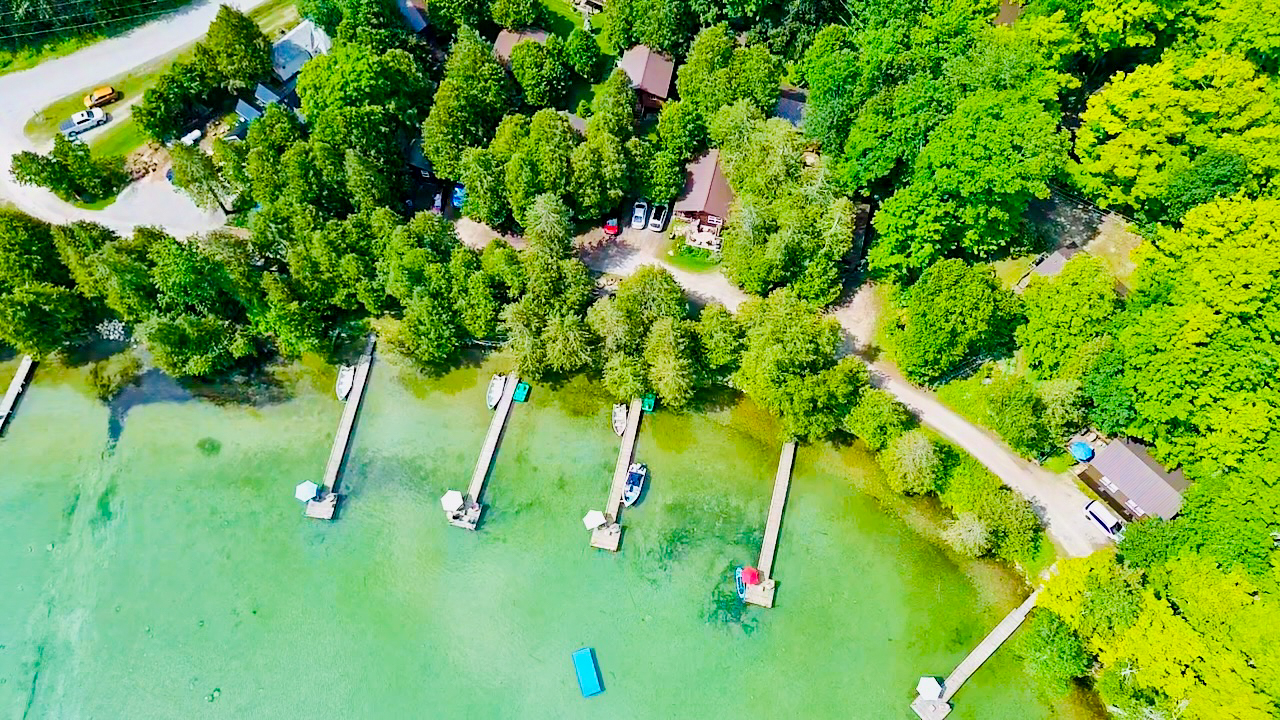 A stunning aerial perspective showing the resort’s sandy shoreline and multiple cabin locations.