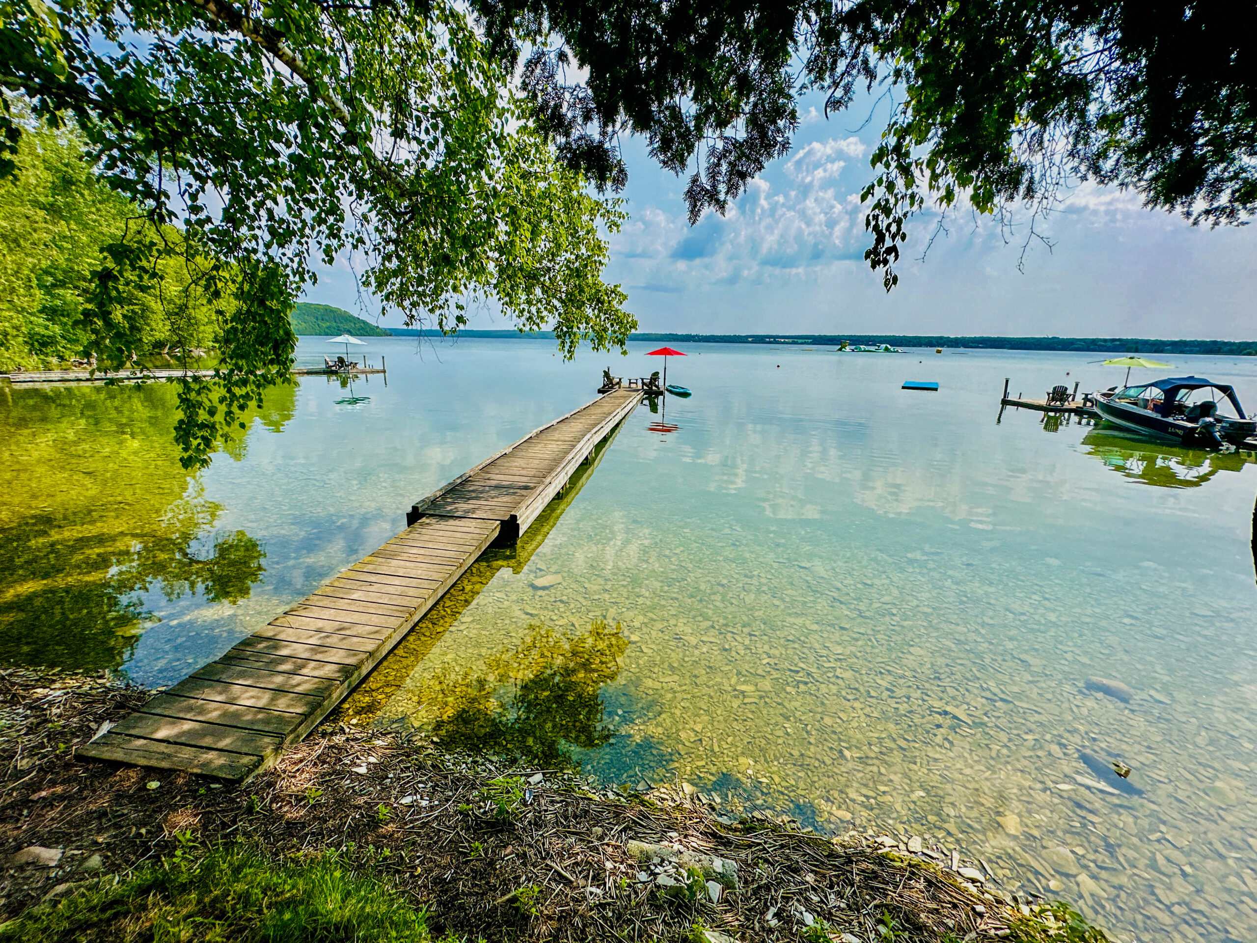 A breathtaking lakeside view at sunset, reflecting golden hues on the water.