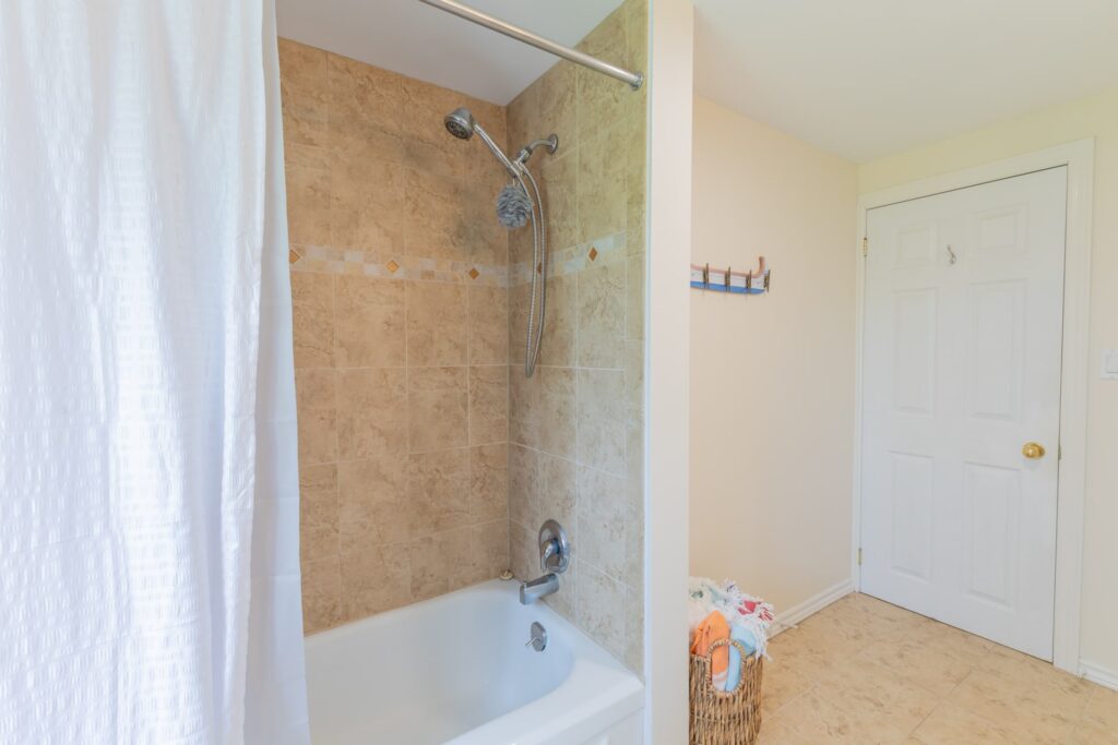 A white bathtub with an open shower curtain