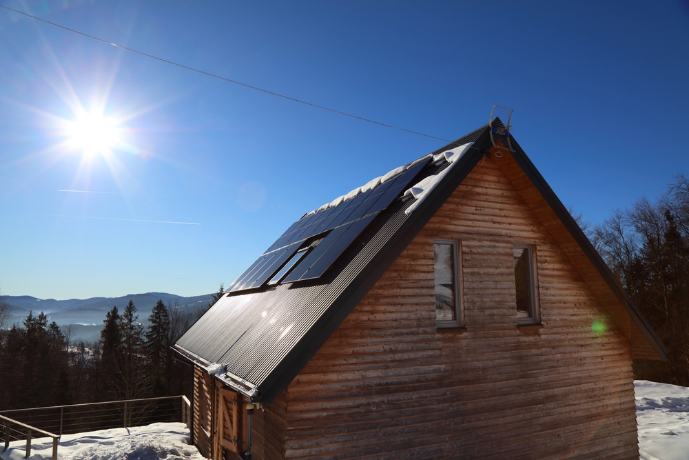 A cabin with solar panels against a winter background