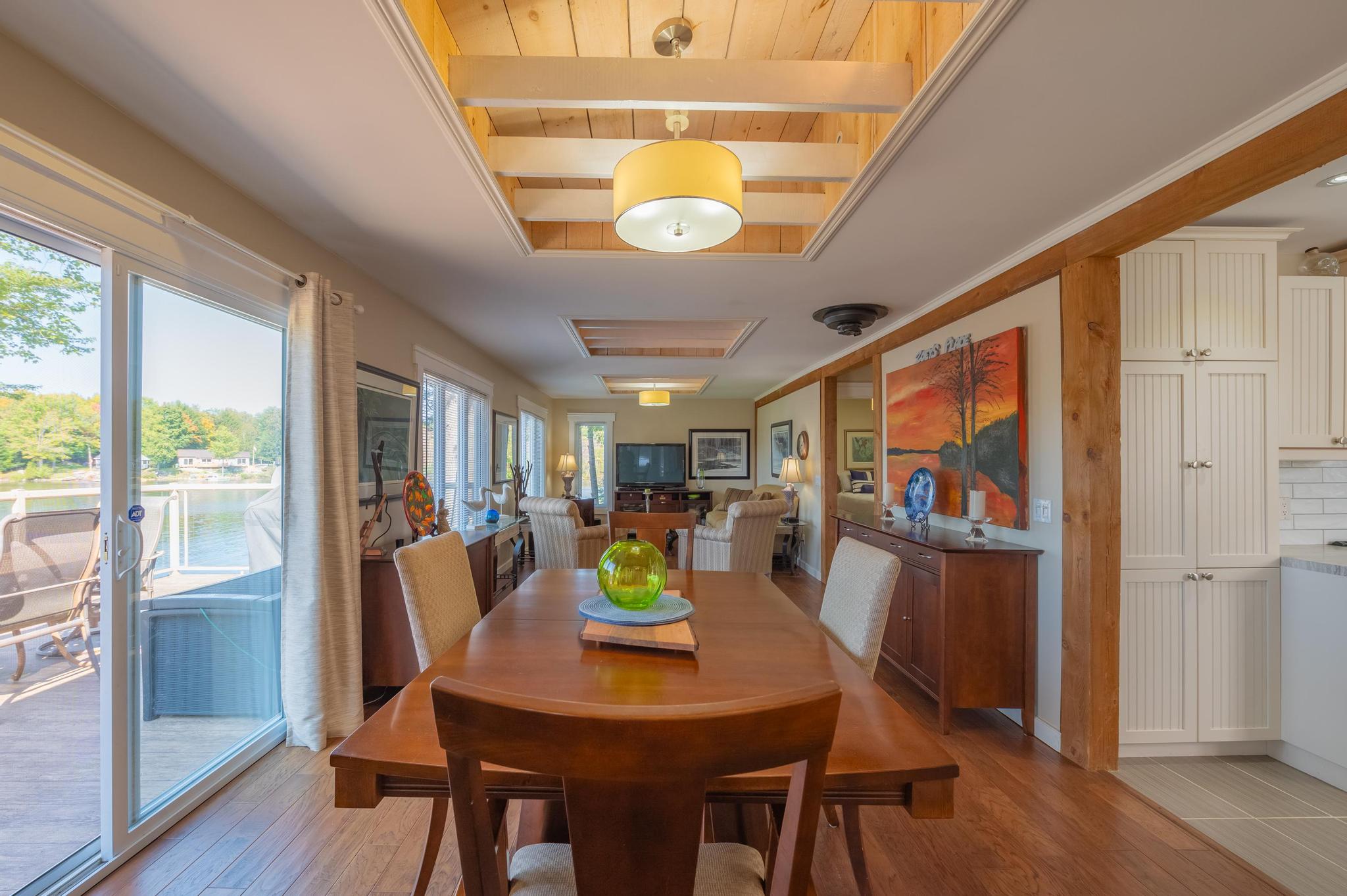 A dining area with a wooden table and large windows that let in natural light.