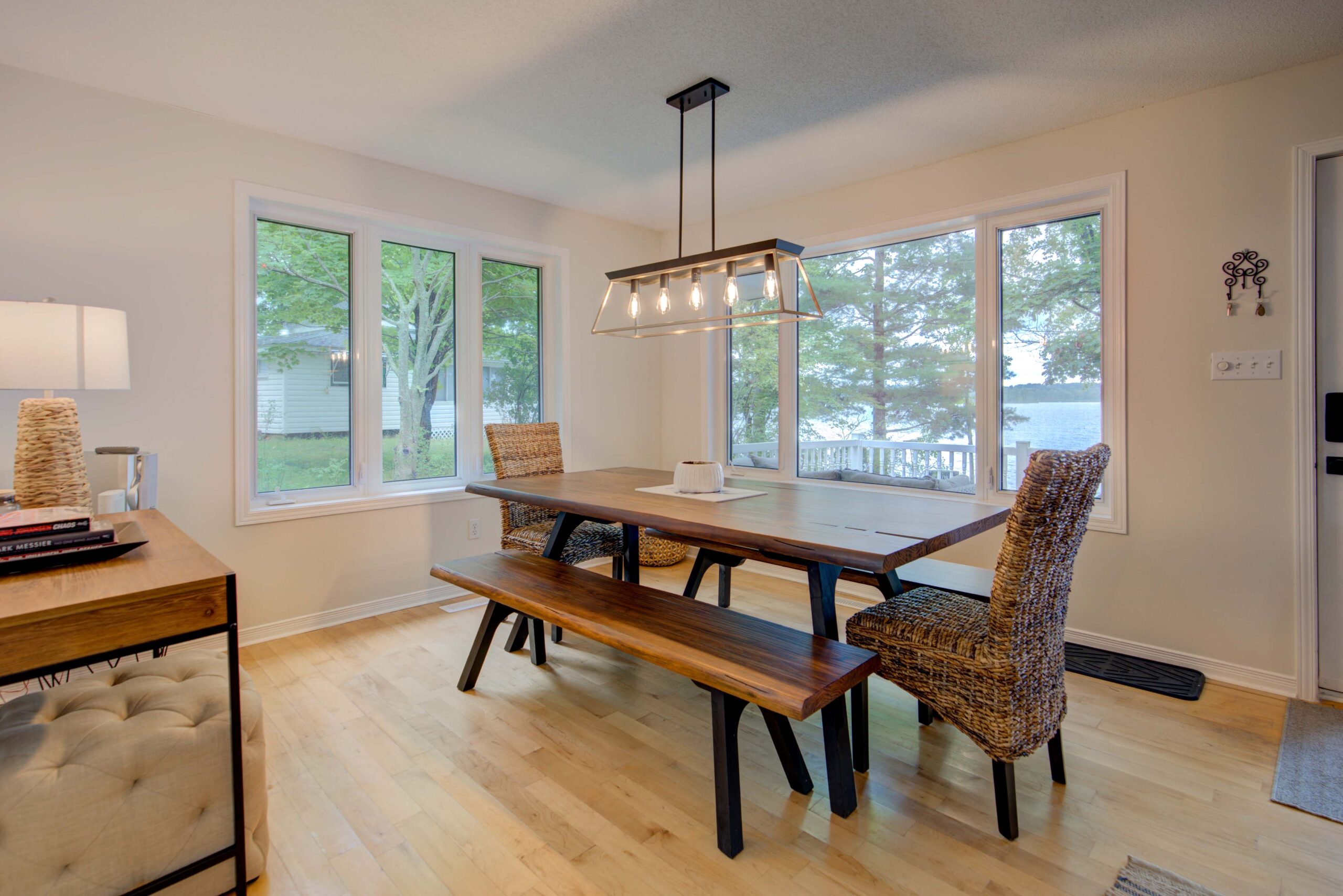 A wood dining table with long wood benches and chairs at the end