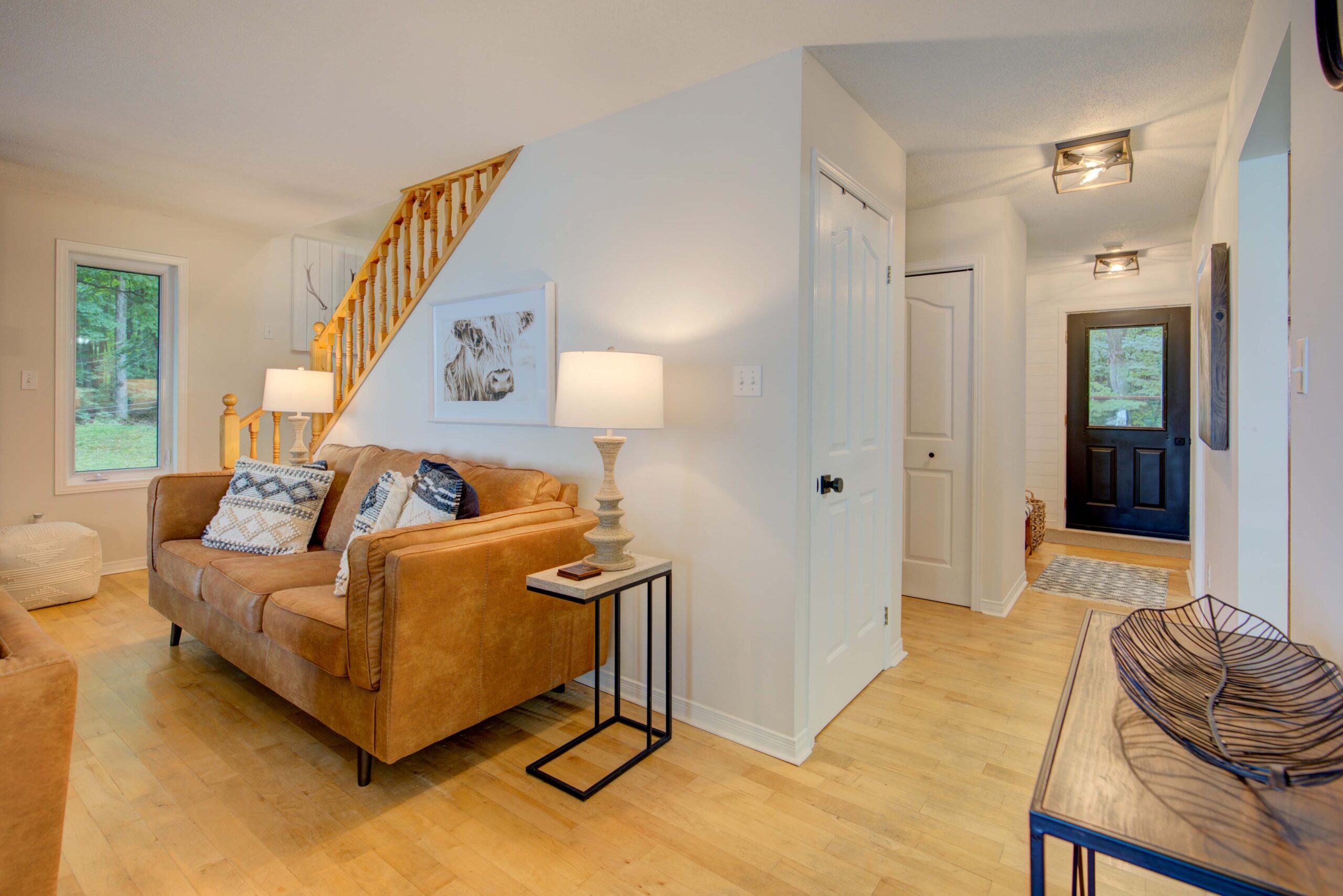 A wood dining table runs parallel to a white and black kitchen