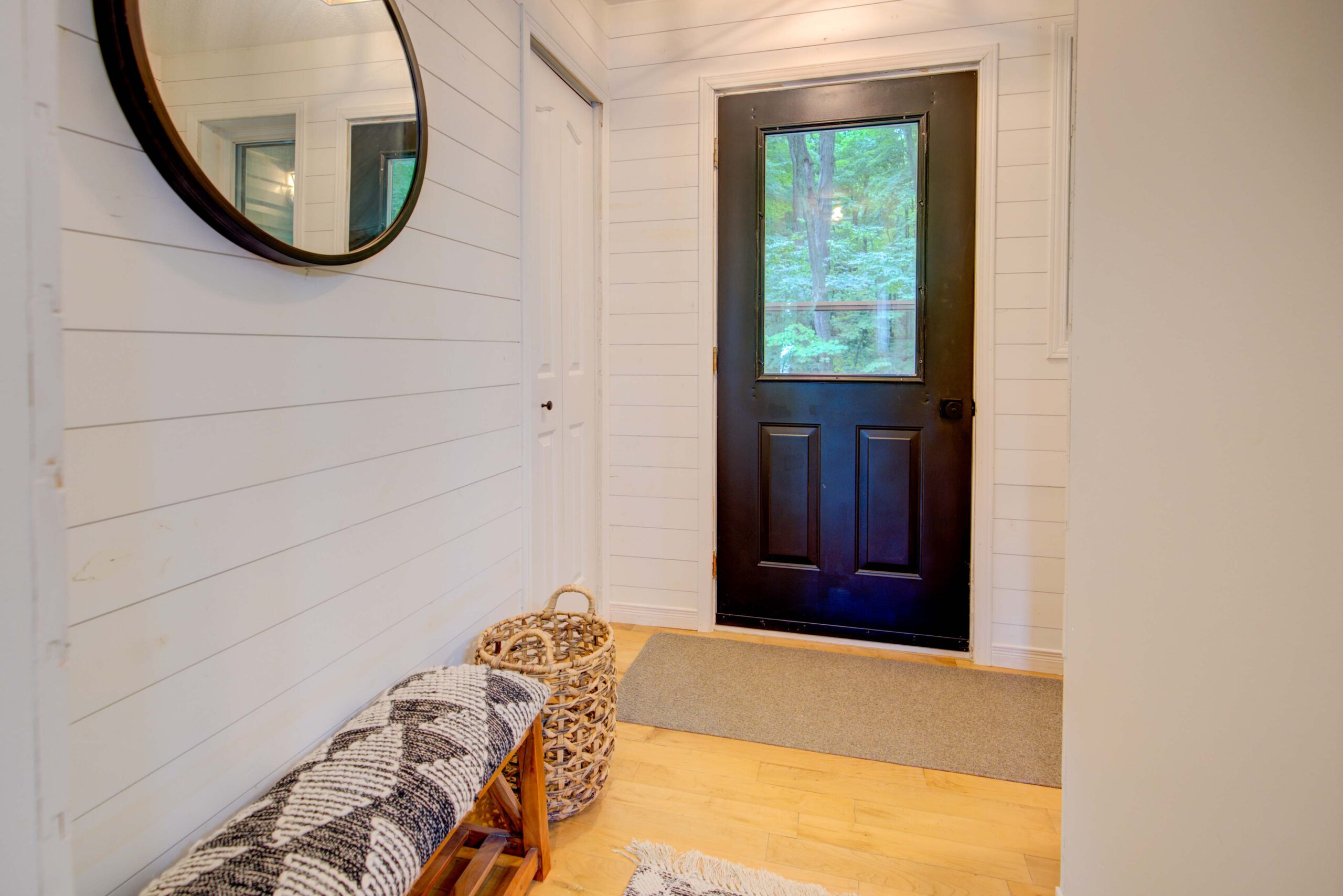A white hallway leads to a navy blue door.