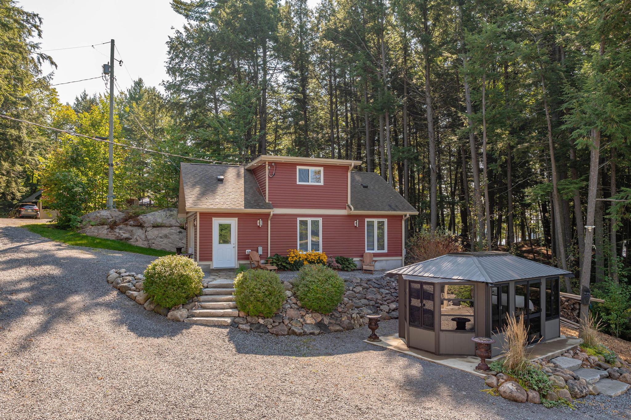 A rear view of the cottage featuring extensive landscaping and a well-maintained outdoor space.