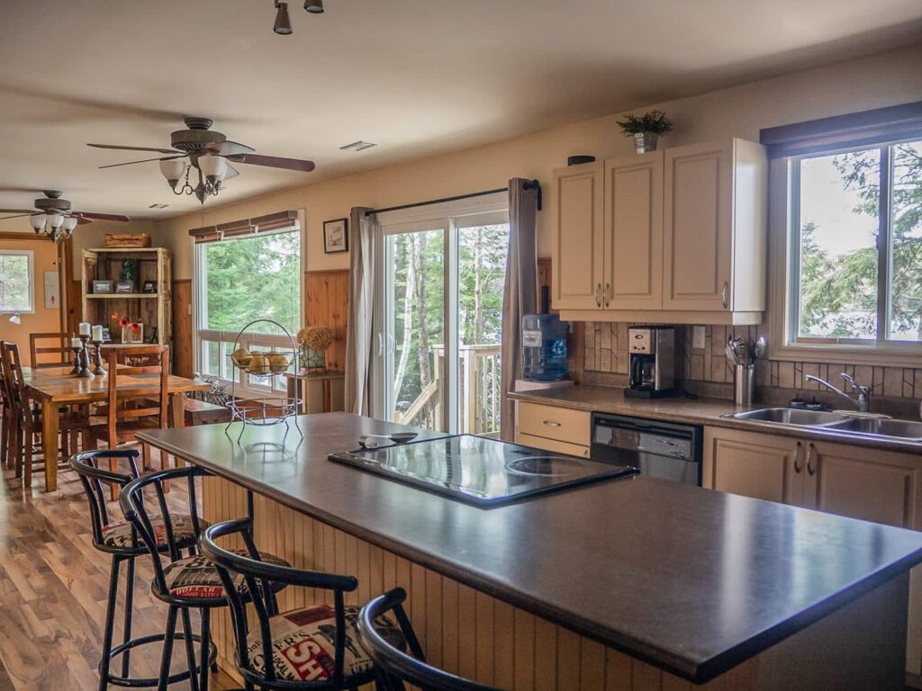 A kitchen island with high-top chairs in a white kitchen