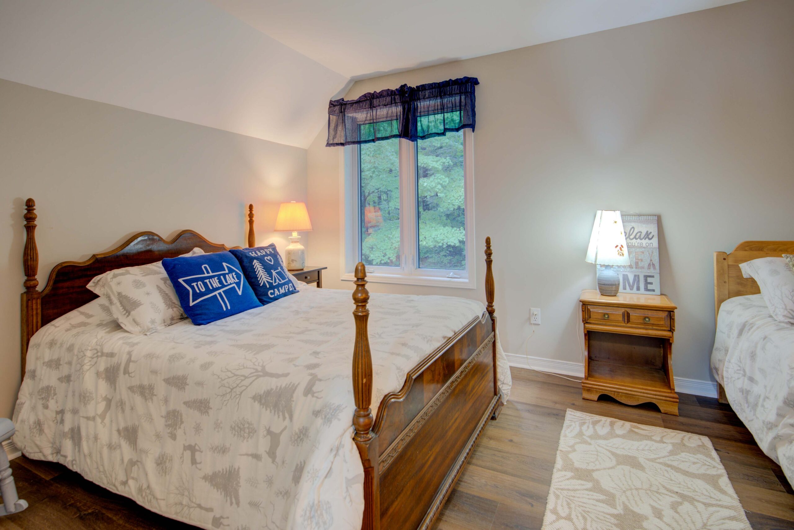 A white bathroom with a white toilet, sink, and walk-in shower