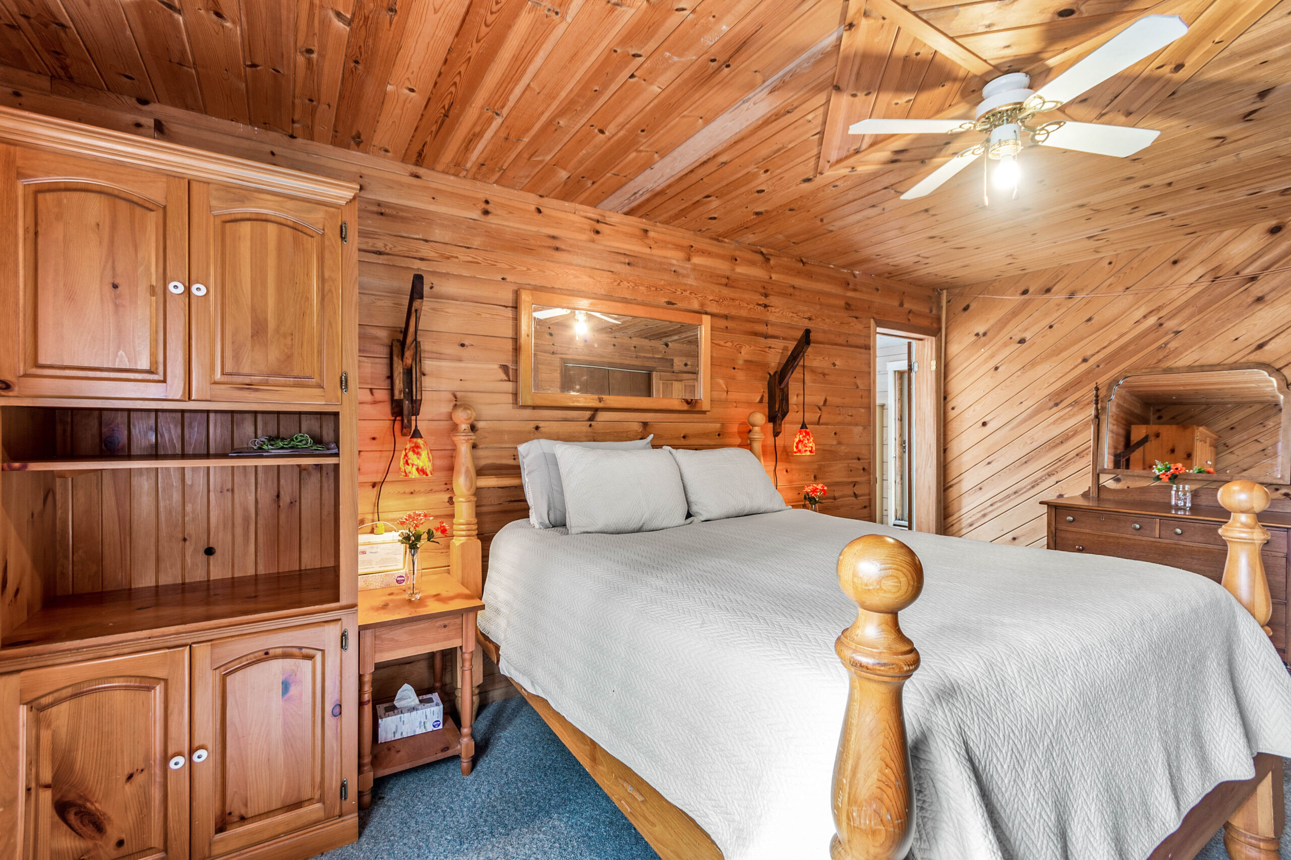 A white bed in a wood-paneled room