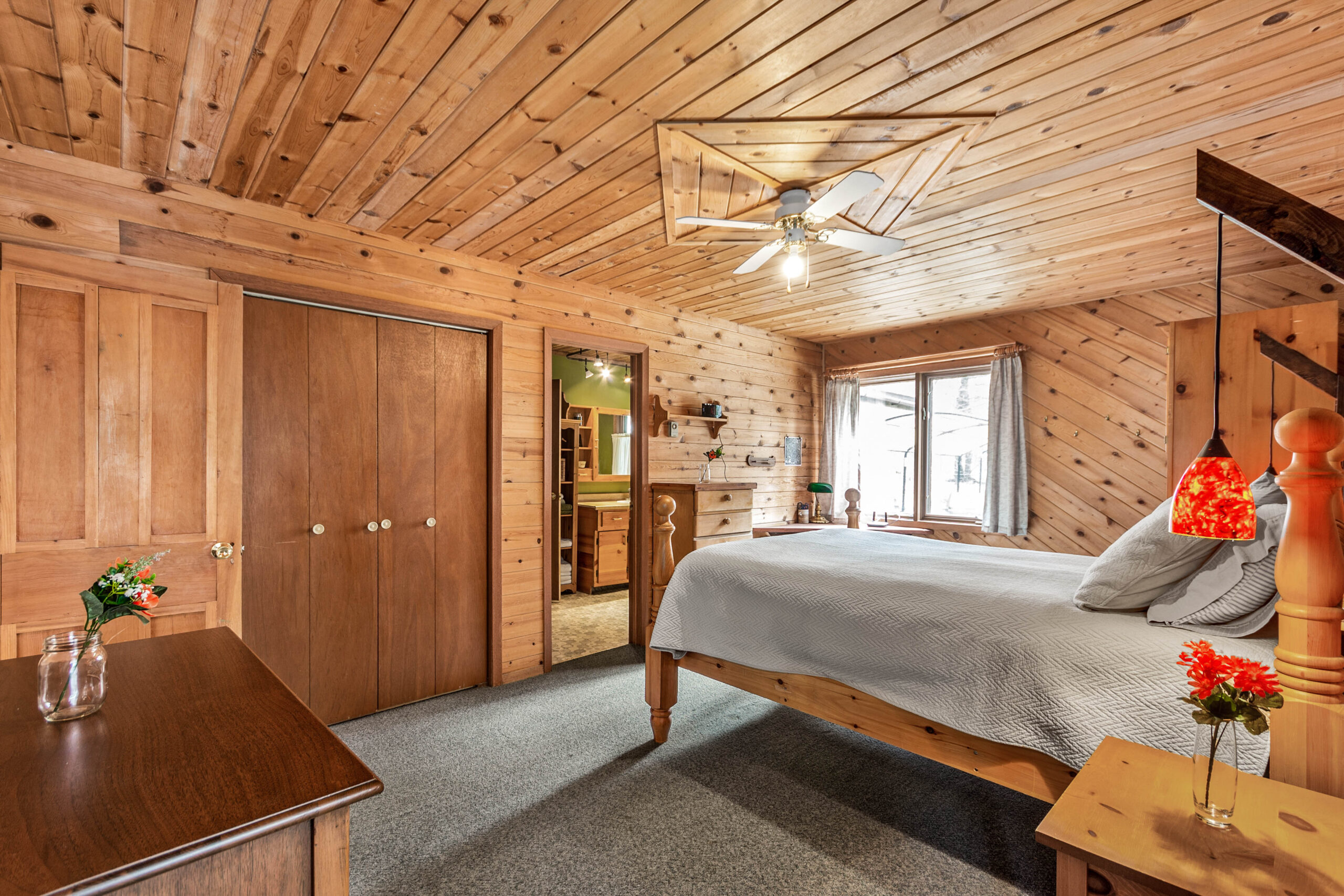 A white bed in a wood-paneled room