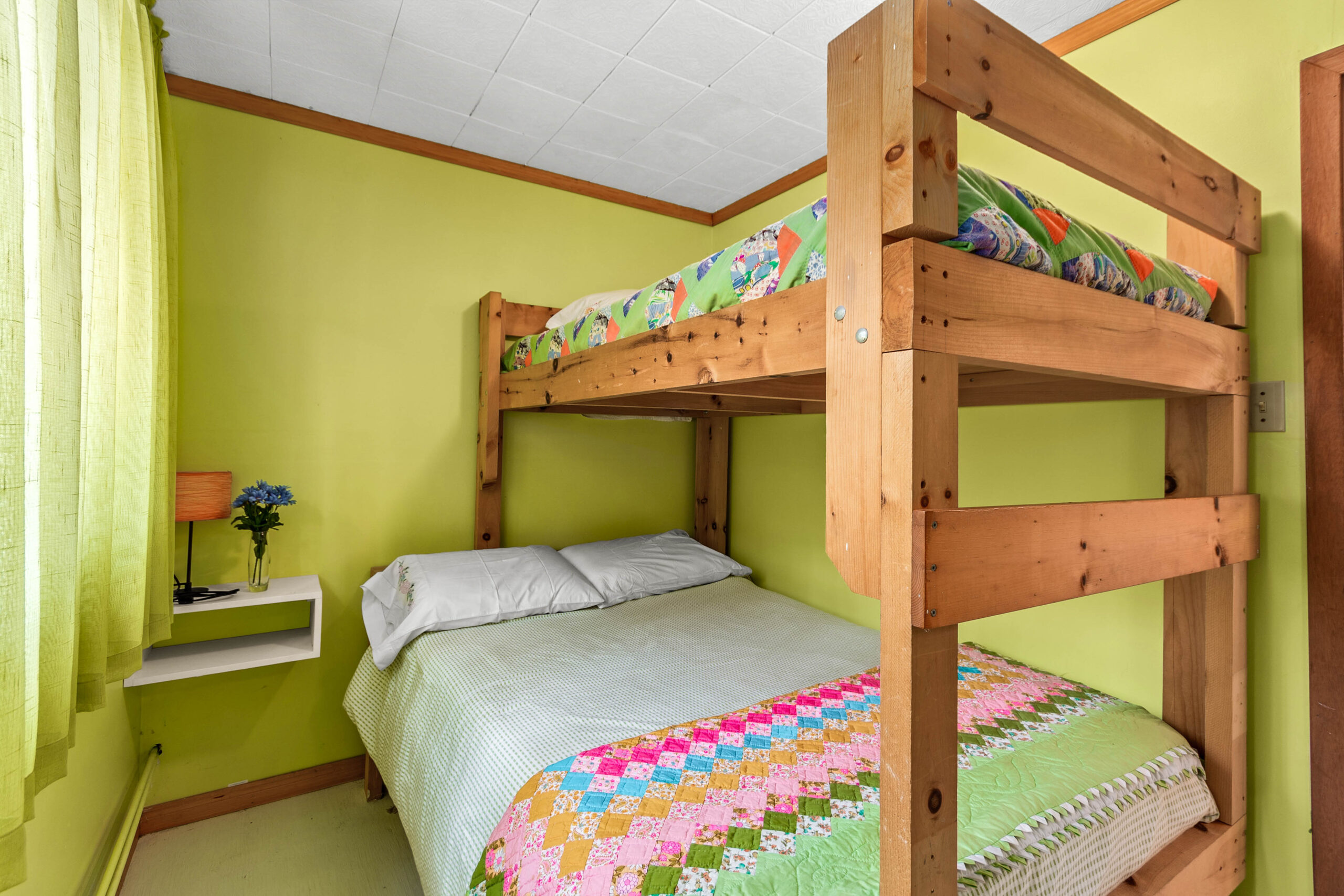 Wooden bunk beds in a lime green room