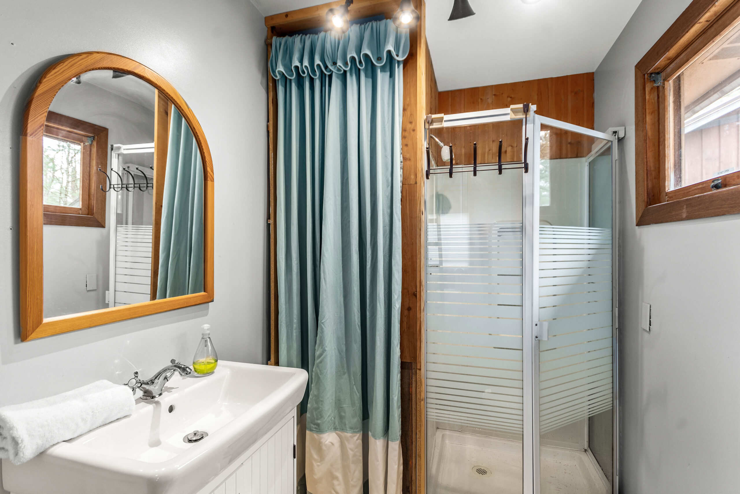 A white bathroom with a blue shower curtain