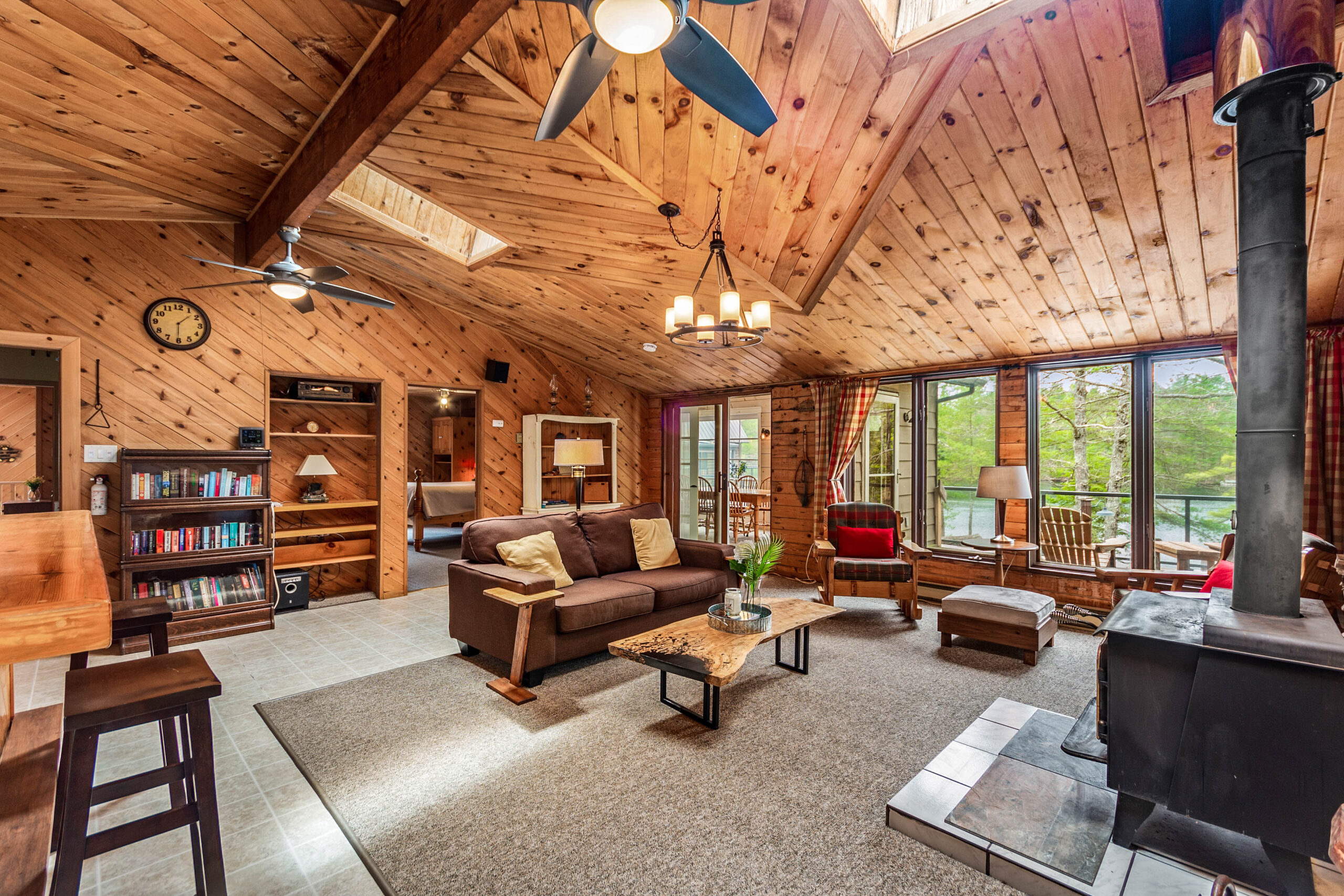 A spacious wood-paneled room with a brown couch and a wood table