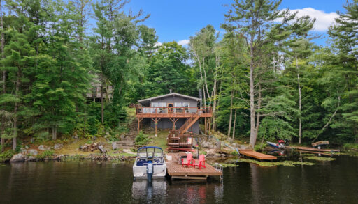 A grey cottage with a dock in front