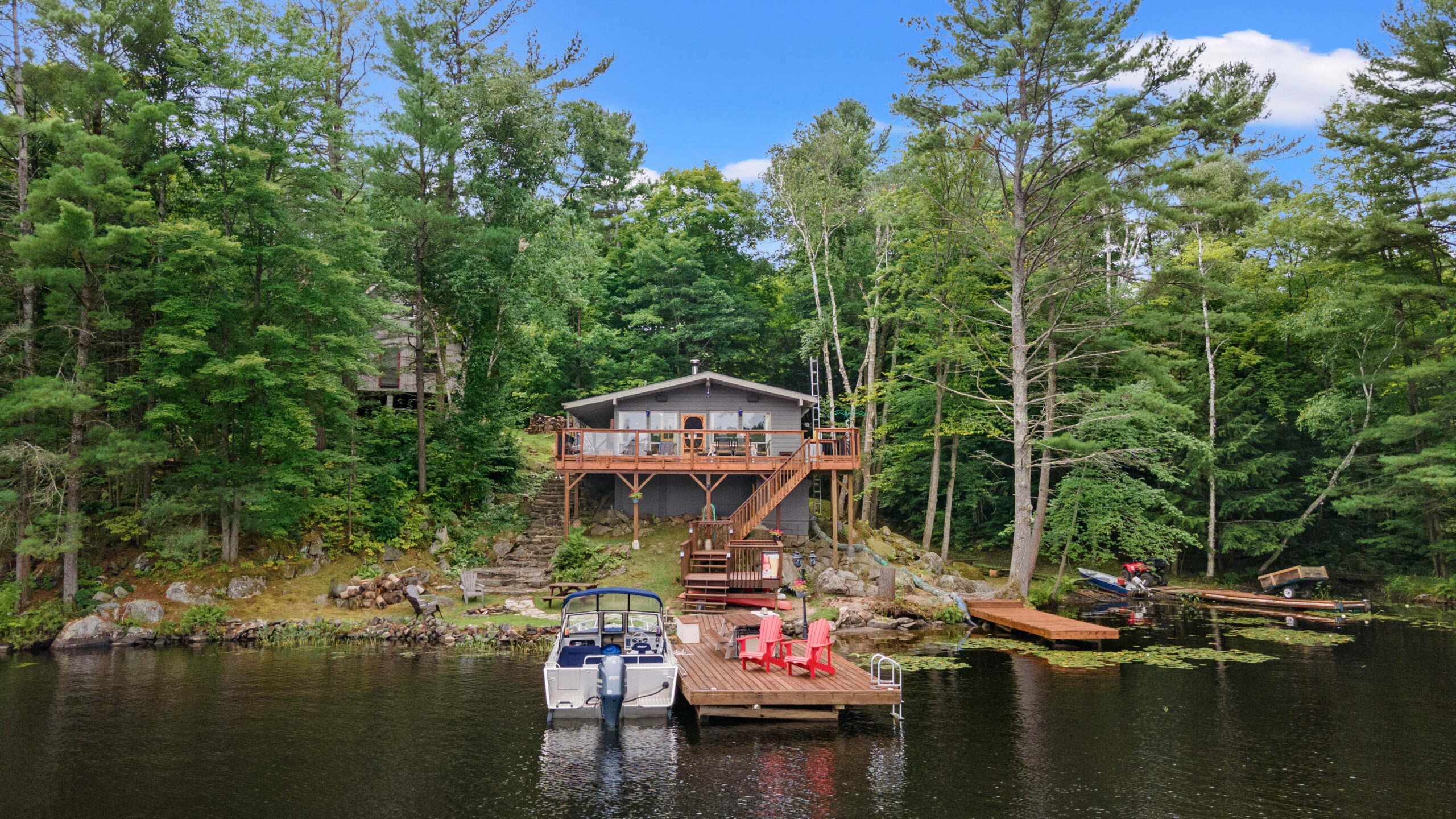 A grey cottage with a dock in front