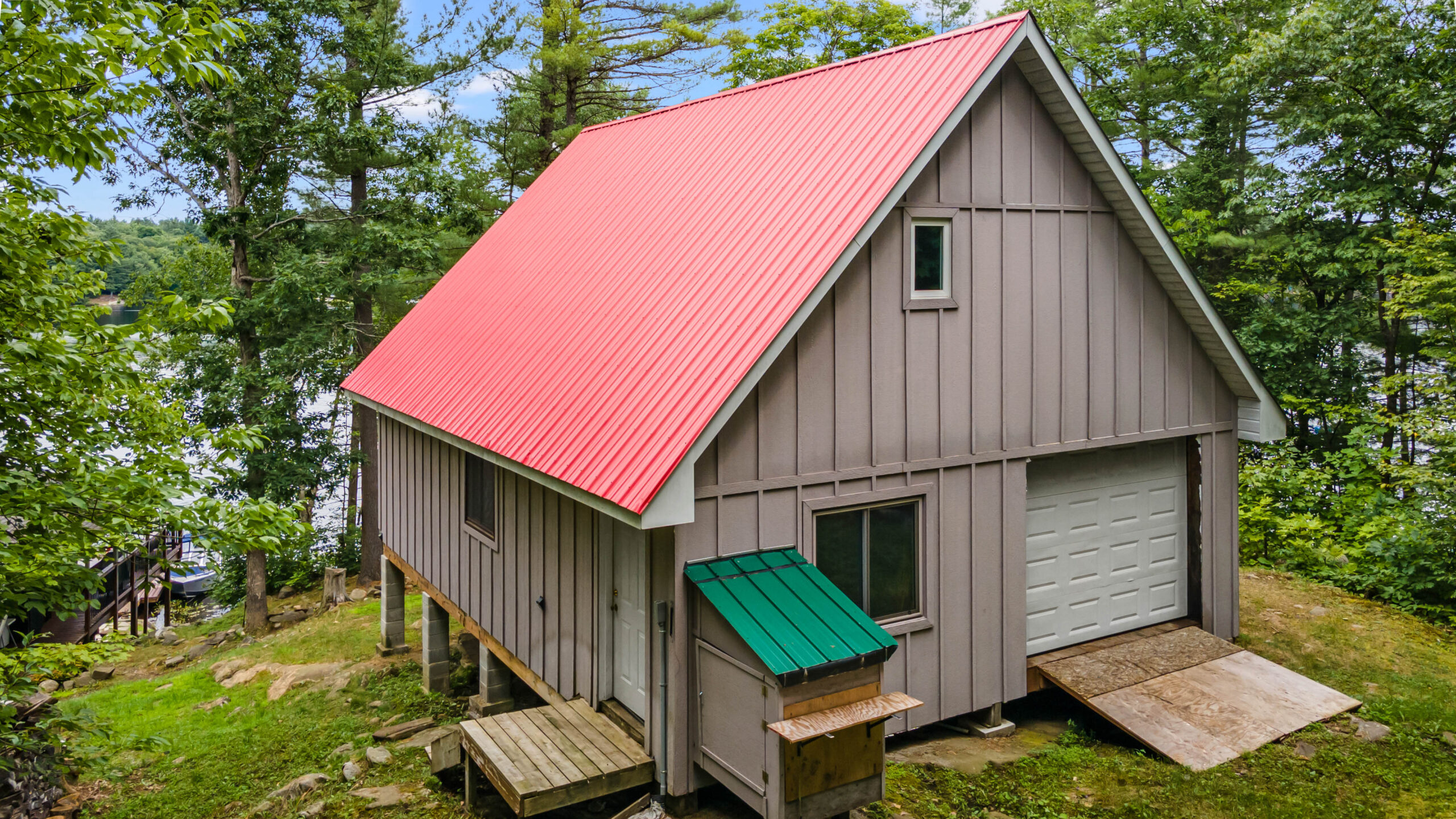A light grey barn with a red roof