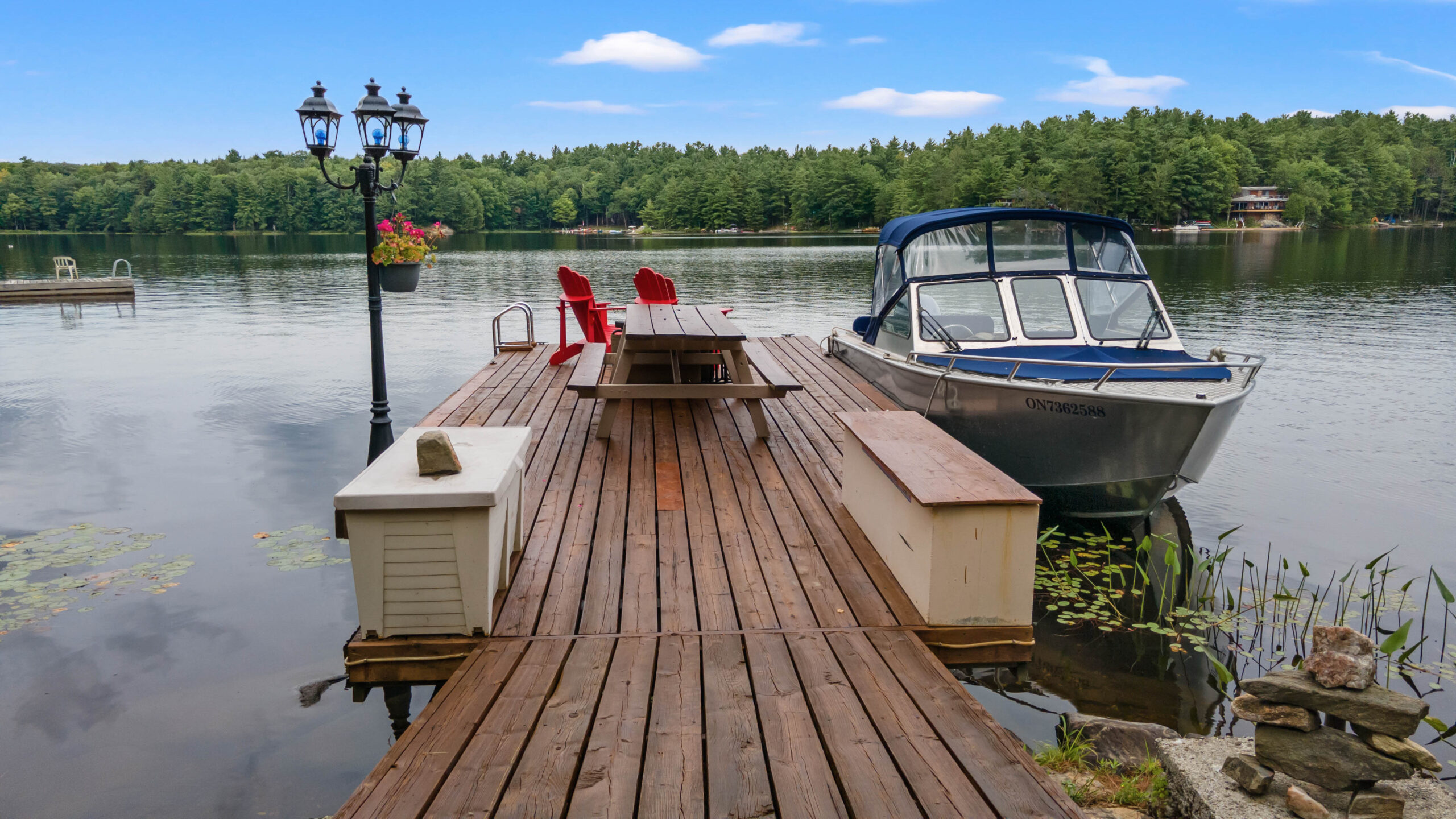 A dark brown dock with a blue boat parked on the right
