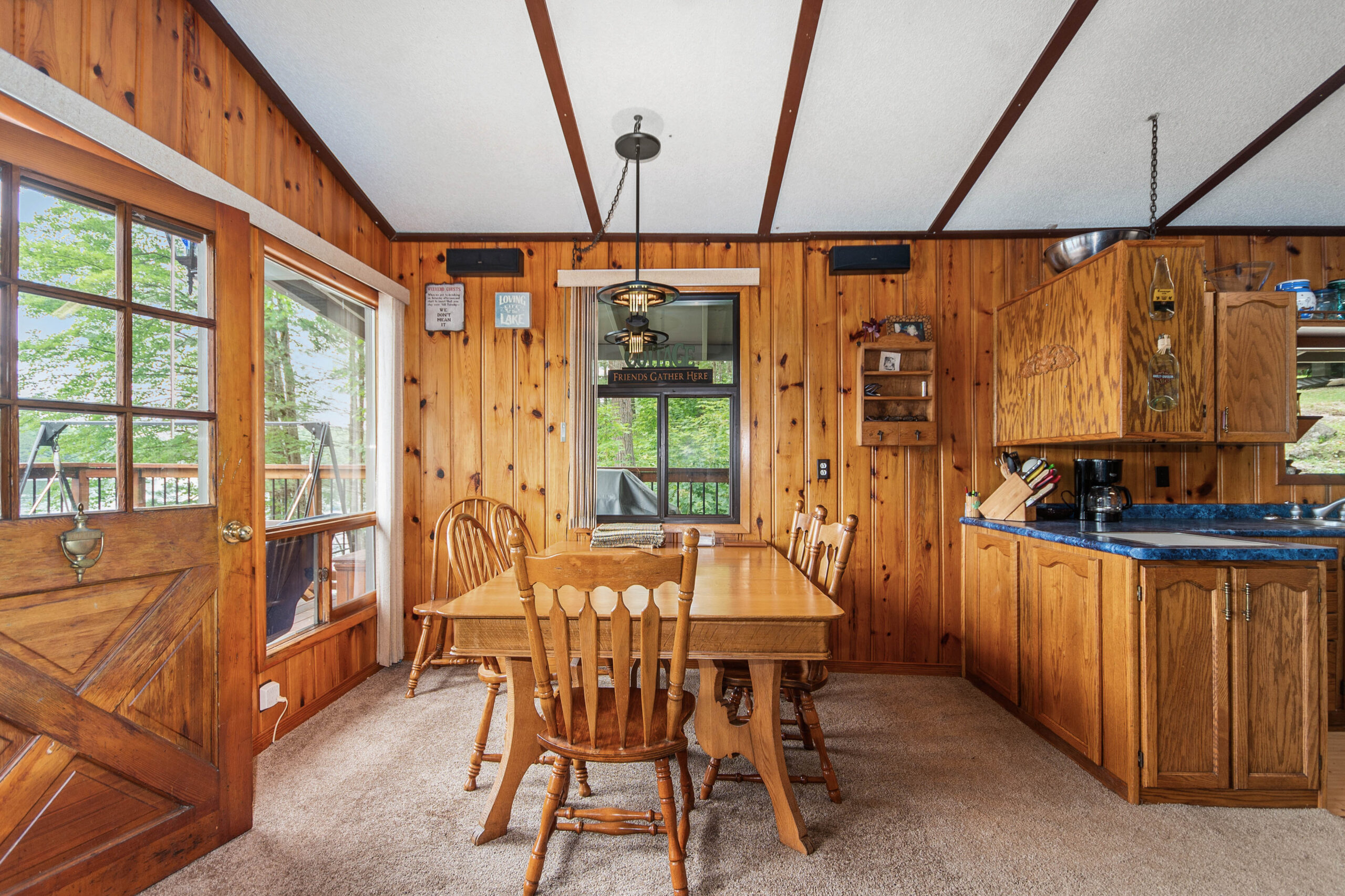 A wood dining table with chairs in a wood-paneled room