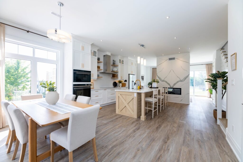 A bright open-concept kitchen with white cabinets and a wood island
